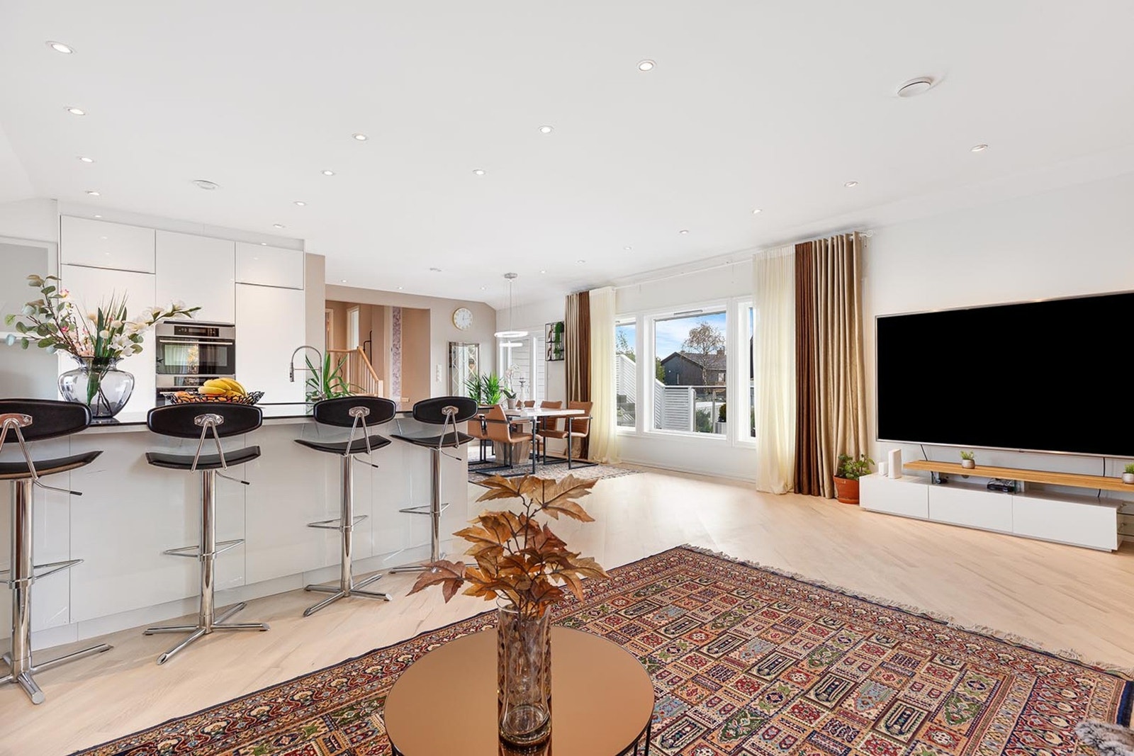 Boligen byr på en innbydende og sosial atmosfære med en moderne åpen kjøkkenløsning som elegant knytter sammen kjøkkenet og stuen. Galleribilde