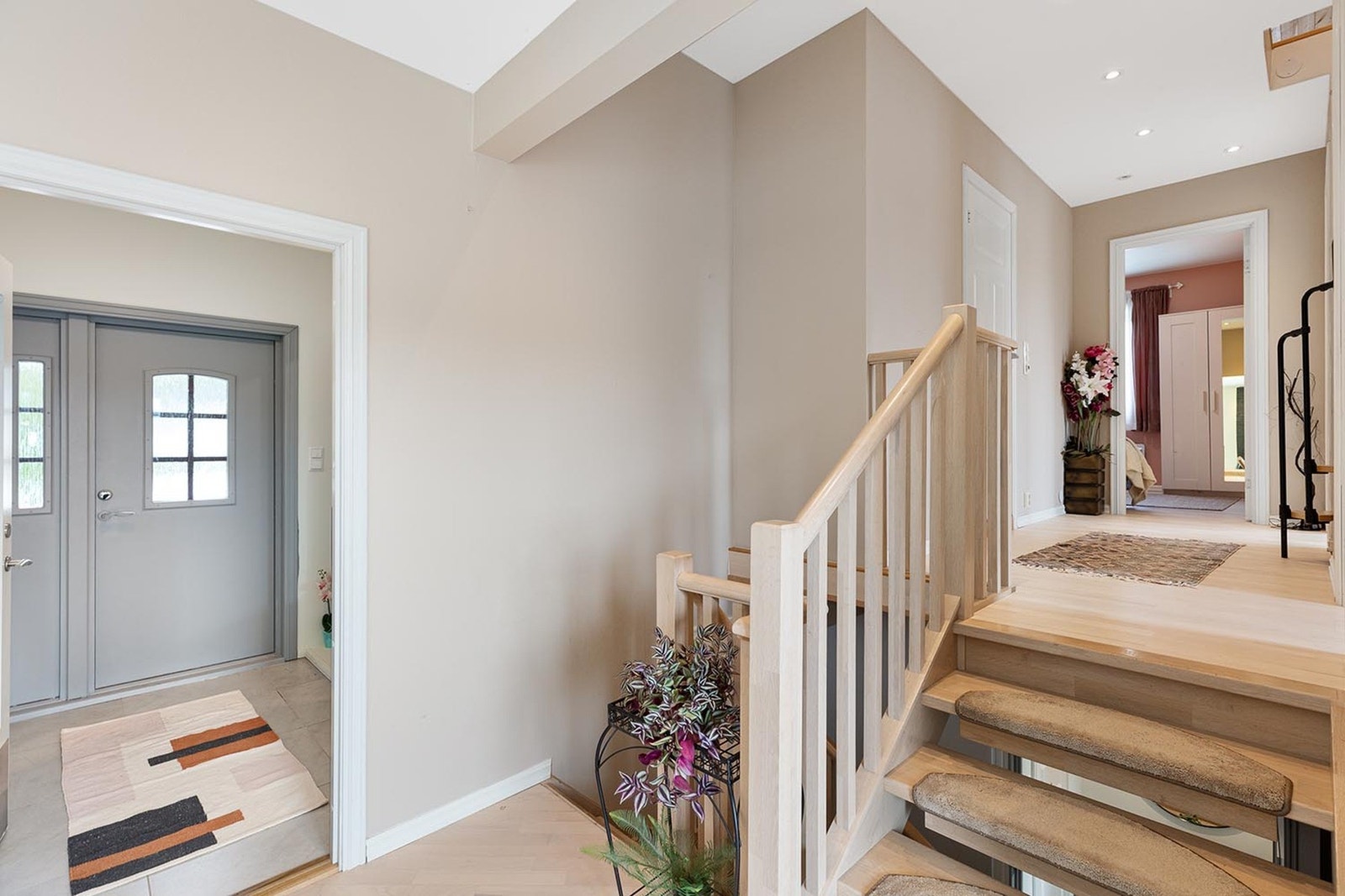 Romslig og lys entré med fliser og varmekabler på gulvet, samt en ny ytterdør fra 2017. Galleribilde