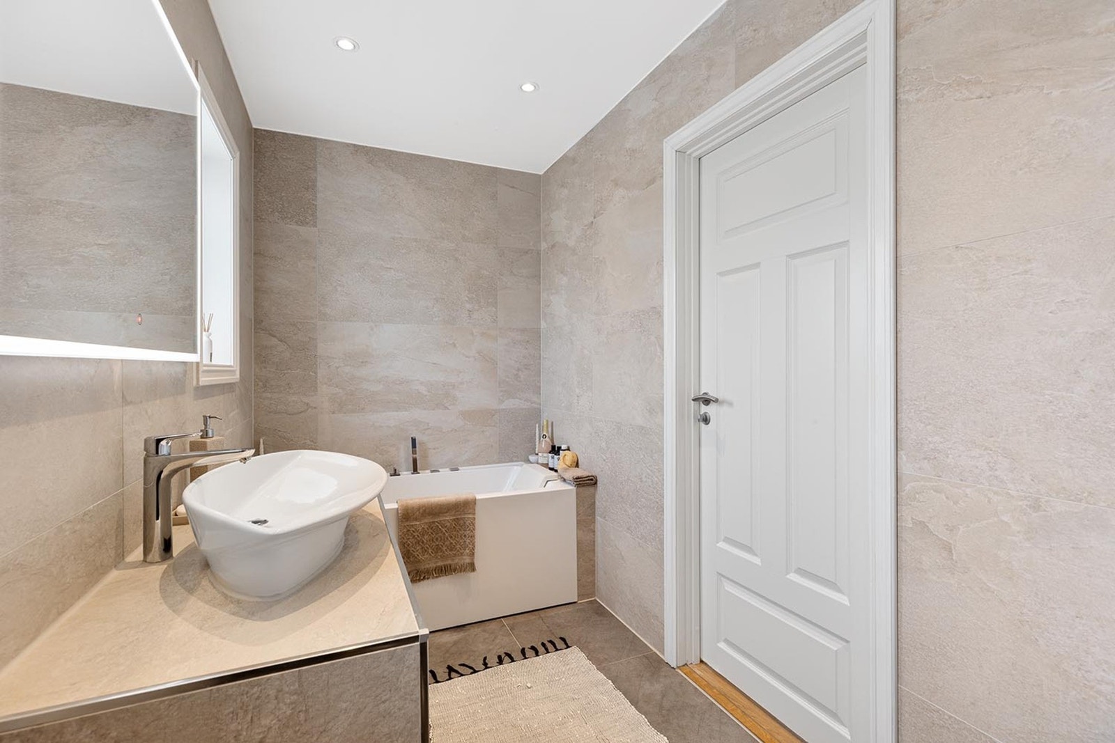 Badet har vegghengt toalett med innebygd sisterne, downlights, og varmekabler i gulvet for komfort. Galleribilde