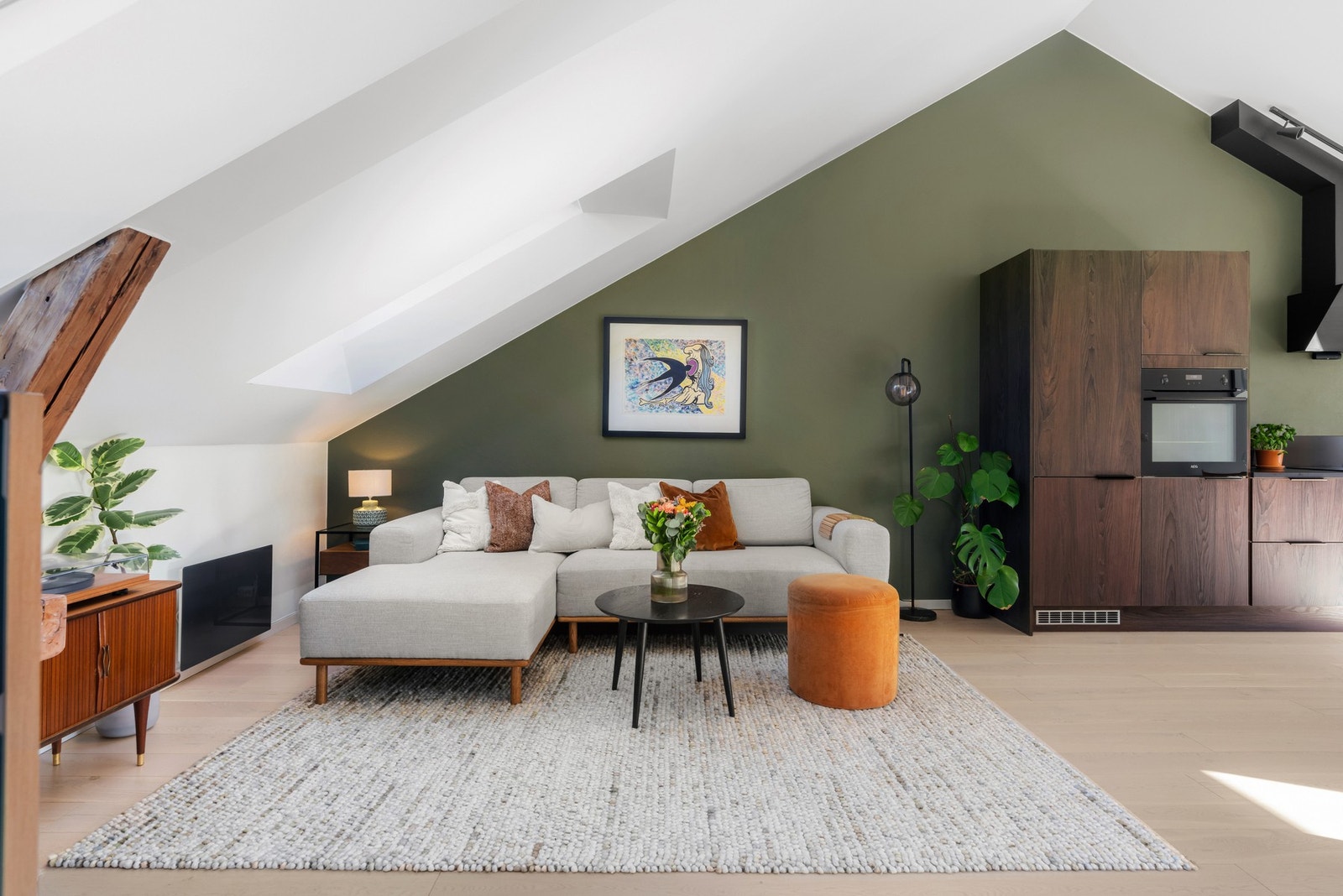 Stuen har lyst 1-stavs parkettgulv og glatte hvitmalte overflater samt én grønn kontrastvegg Galleribilde