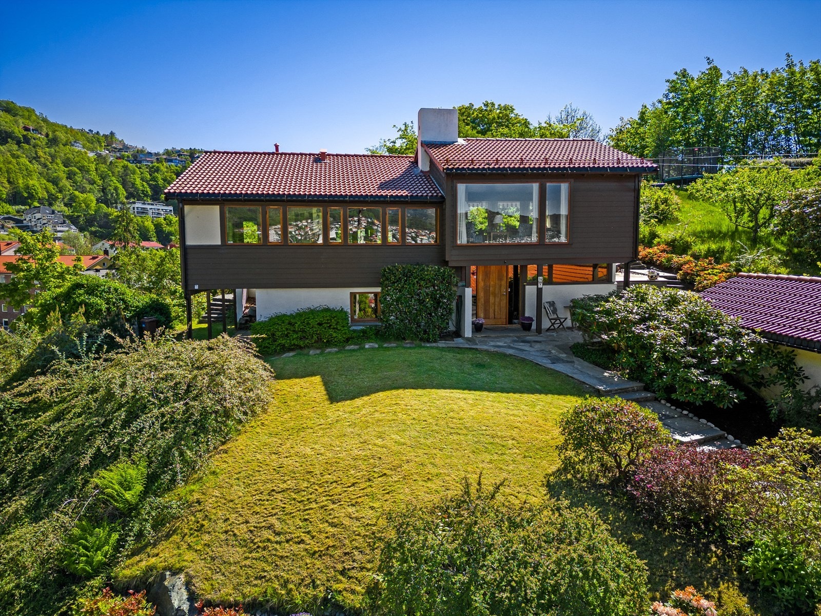Tomten er svært flott opparbeidet med plenareal og variert, frodig beplantning. Galleribilde