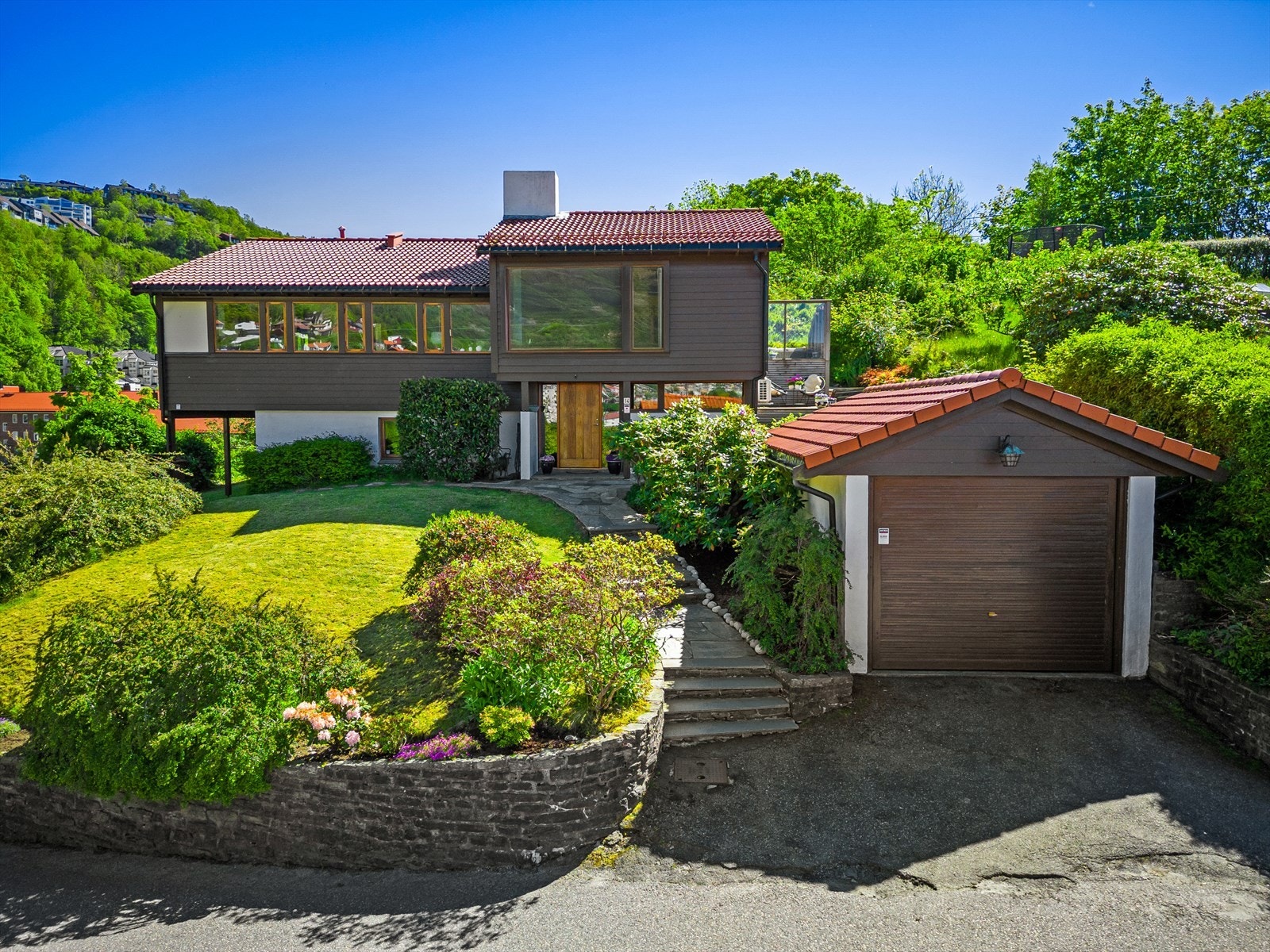 Tomten har gode parkeringsmuligheter med garasje (elbillader installert i 2023) og biloppstillingplass utenfor. Galleribilde