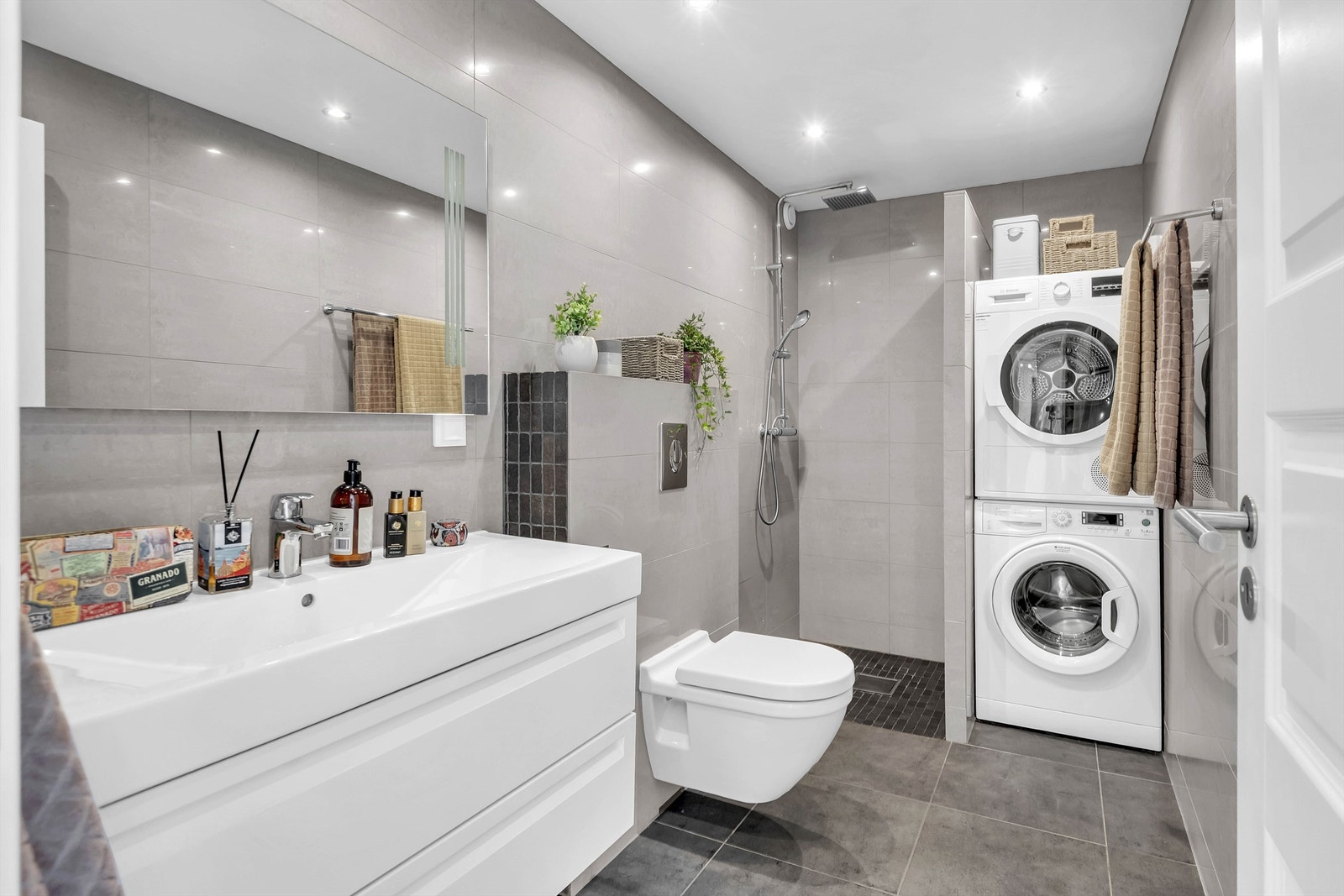 Delikat og moderne baderom fra 2012. Flislagte vegger og malt himling. Dusjnisje med dusjgarnityr. Gulvmontert toalett. Servantinnredning med skuffer, servant og ett greps blandebatteri. Galleribilde