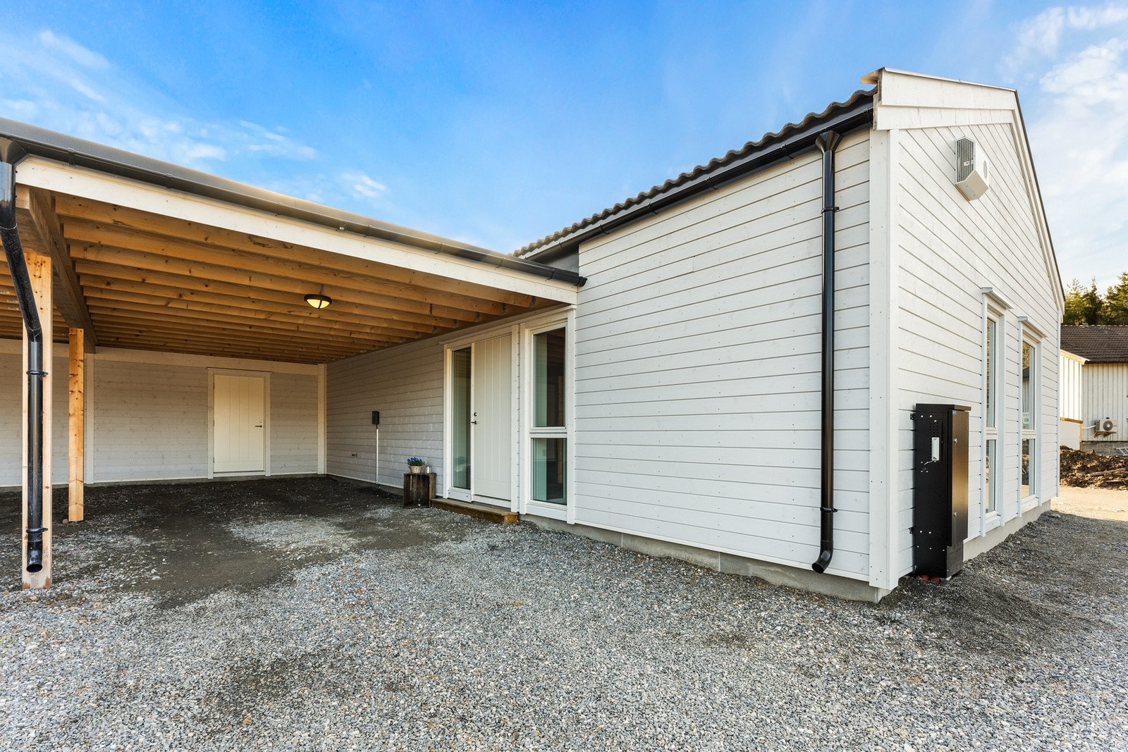 Carport tilhørende boligen med større utvendig lagringsbod bakerst Galleribilde