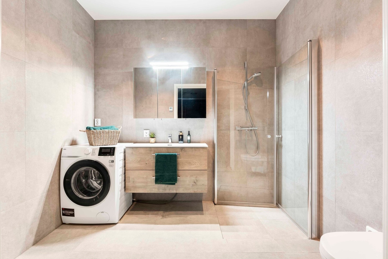 Lekkert baderom med opplegg for vaskemaskin i tilknytning til hovedsoverommet. Galleribilde