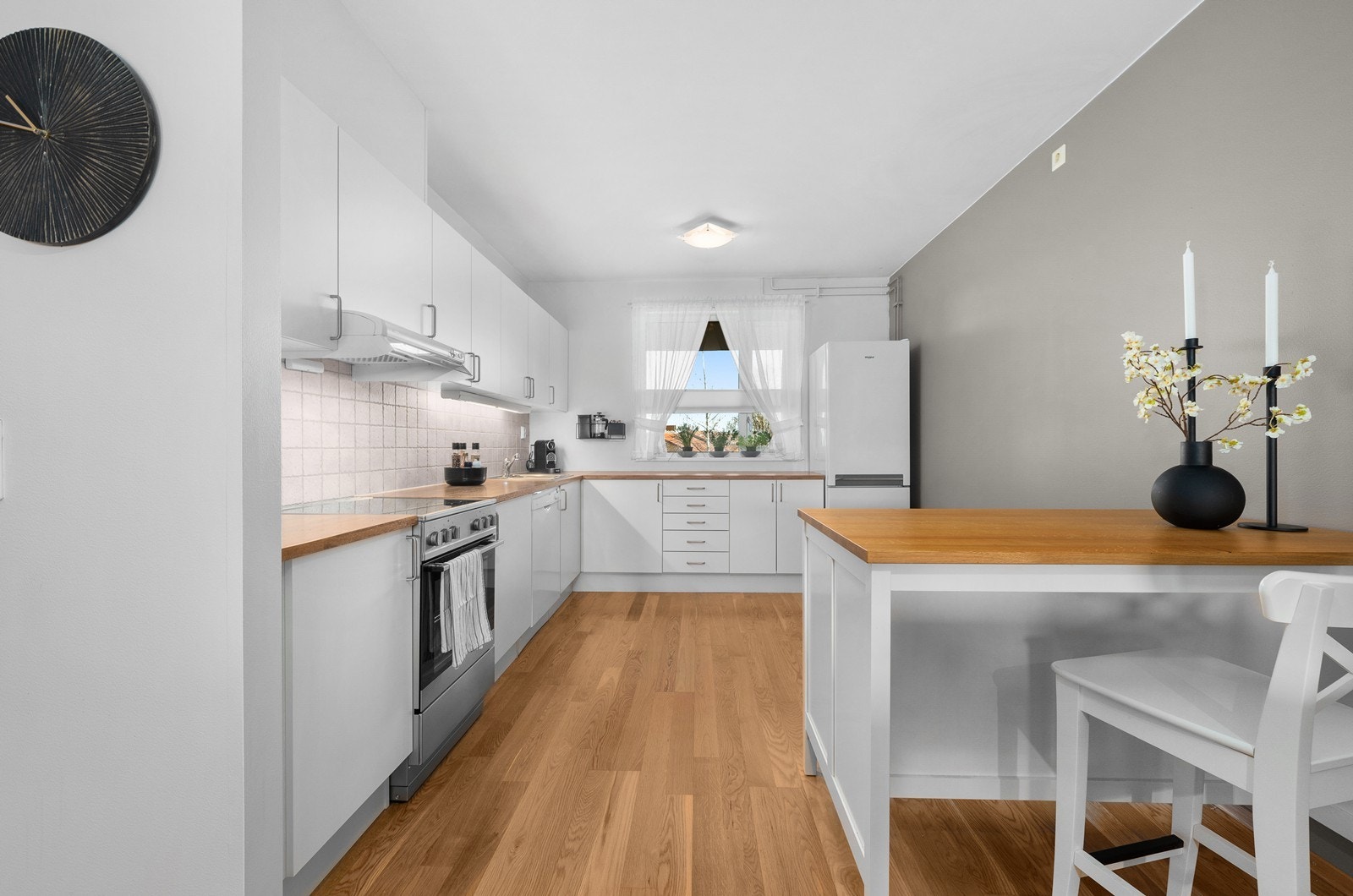 Kjøkkenet har en hvit, tidløs innredning med plass for frittstående hvitevarer. Galleribilde