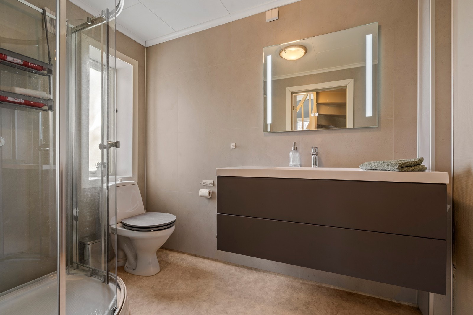 Pent oppusset bad i første etasje. Satt inn nye baderomsplater, baderomsmøbel, servant, speil og dusjkabinett i 2025. Galleribilde