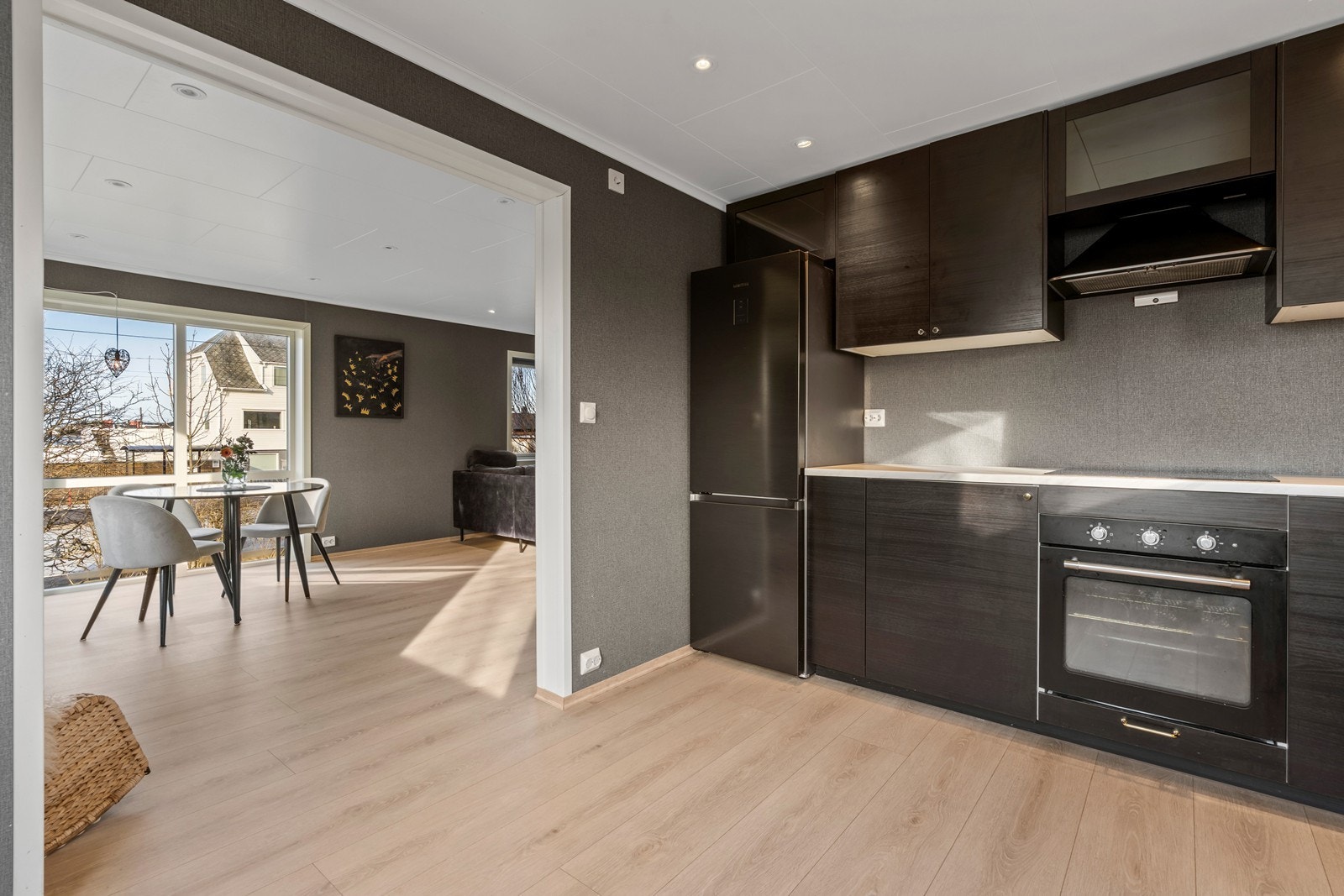 Pen halvåpen løsning mellom stue og kjøkken gjør rommet til et sosialt samlingspunkt. Galleribilde