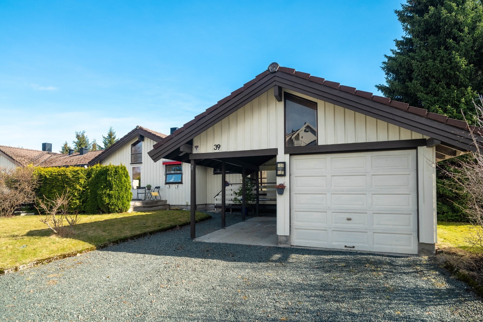 Tomten er pent opparbeidet med gruslagt innkjørsel, garasje med carport og uteområder. Galleribilde