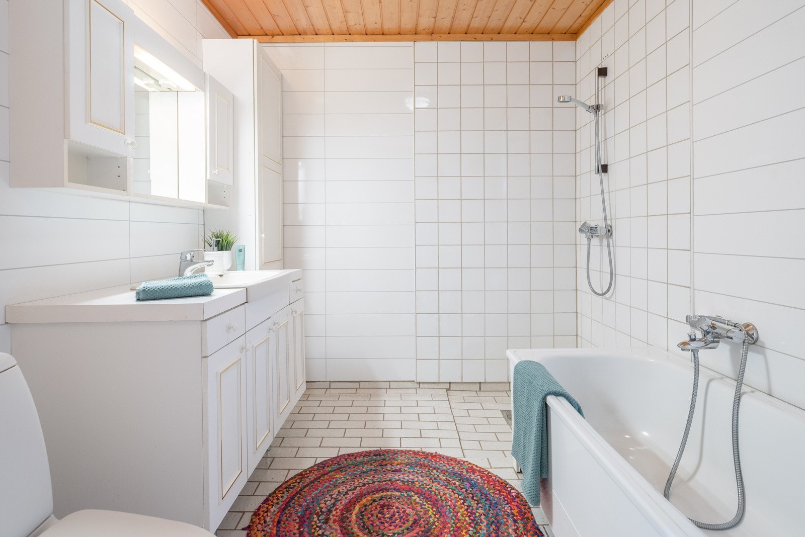 Baderommet måler 6 kvm og er flislagt. Badet er innredet med servant med underskap, speilskap, dusjhjørne, badekar og toalett. Galleribilde