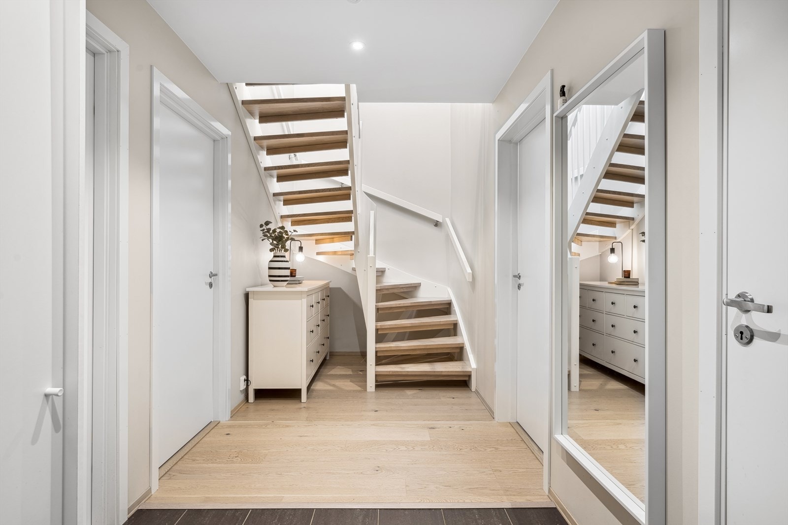 Det er videre en sømløs overgang til parkettgulv som er gjennomgående i den øvrige delen av entreen. Entreen er videre malt i en lys og tidsriktig farge som gir rommet en behagelig fremtoning. Galleribilde