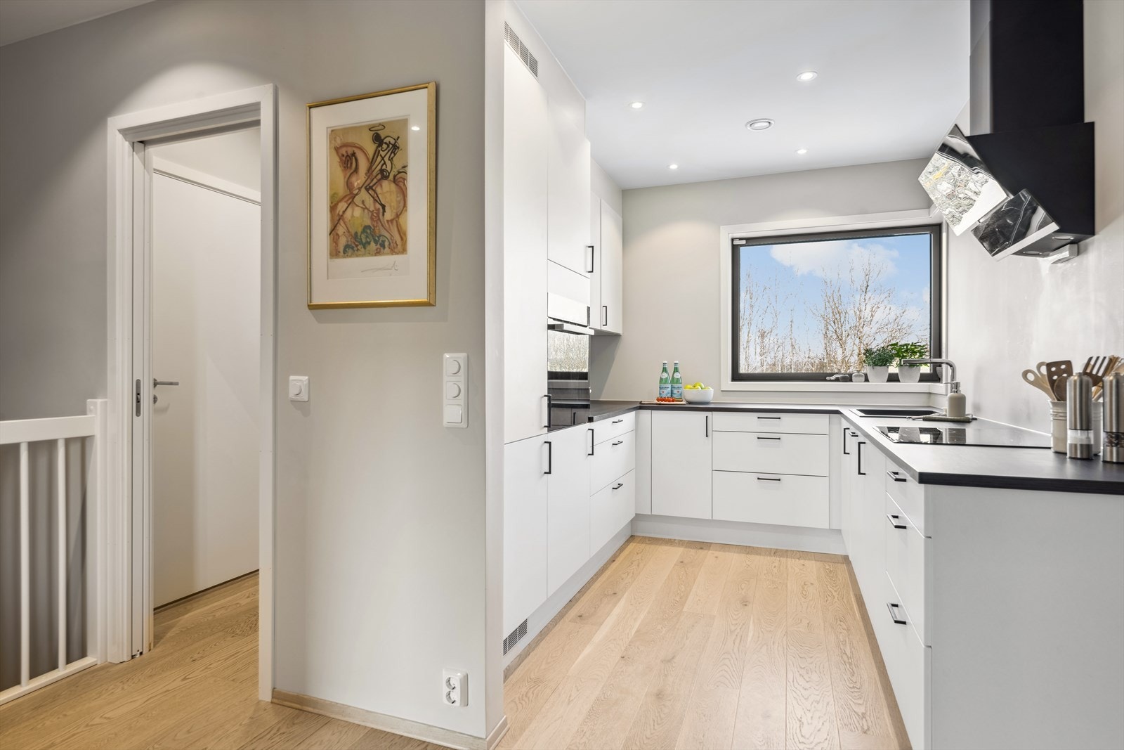 Det flotte kjøkkenet er lokalisert i åpen løsning mot stuen, og har på bakgrunn av sin plassering en naturlig privat sone. Det er montert moderne og lys kjøkkeninnredning med høyskap. Galleribilde