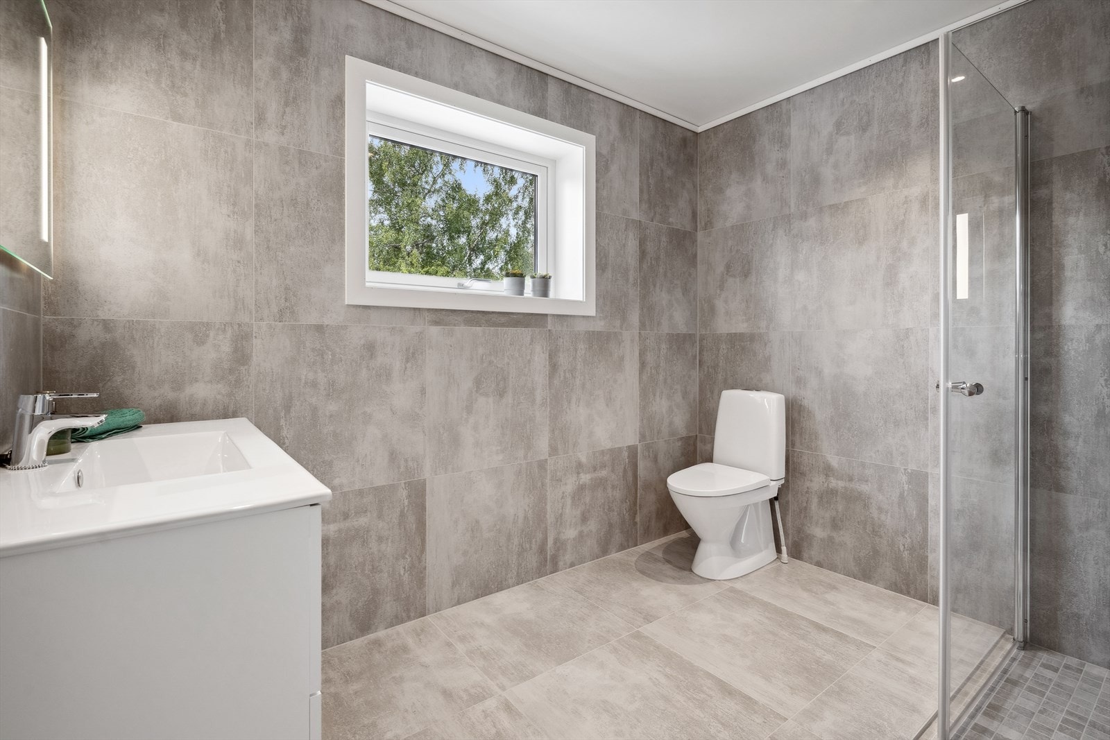 Badet er av delikat utførelse med fliselagt vegger og gulv. Galleribilde