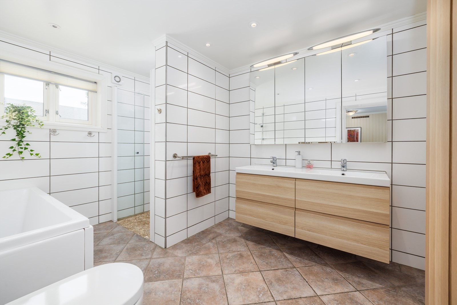 Badet er fra 2014 og har flislagte gulv og vegger samt varmekabler i gulvet Galleribilde