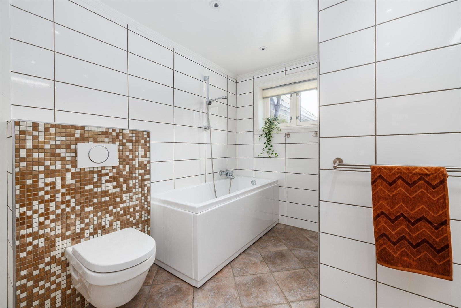 Badekar og en lukket dusjnisje med glassvegg i front. Galleribilde