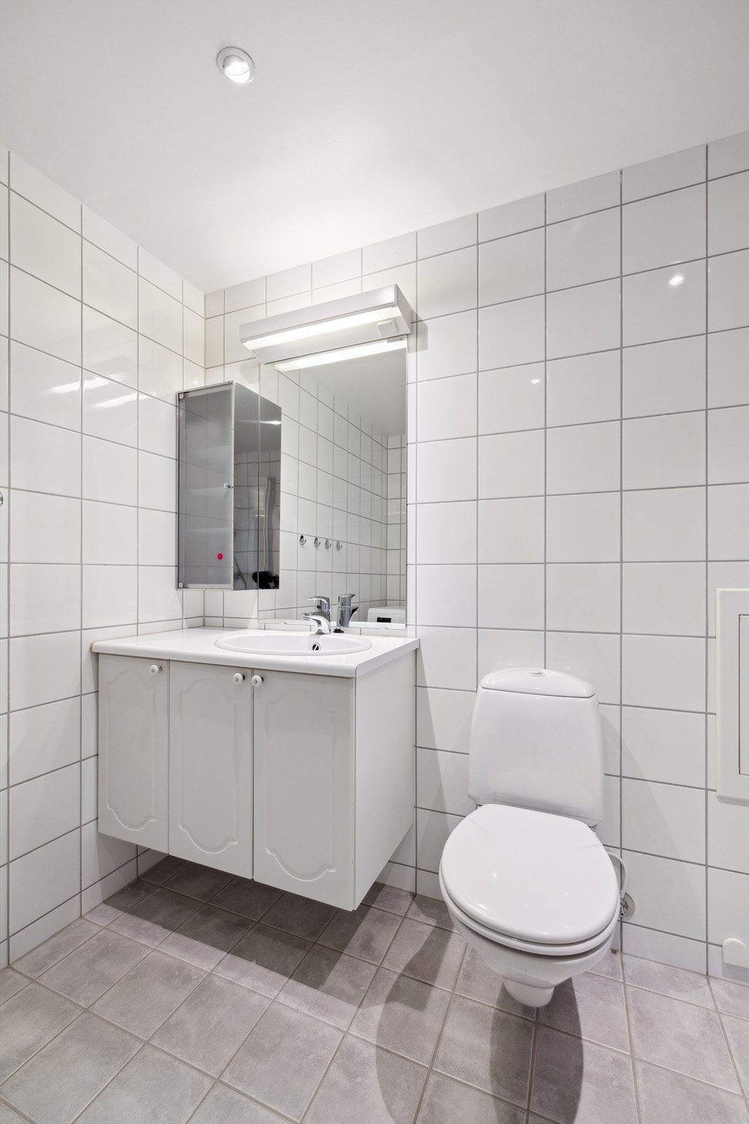 Det er vegghengt servantskap med nedfelt servant og speil med overlys Galleribilde