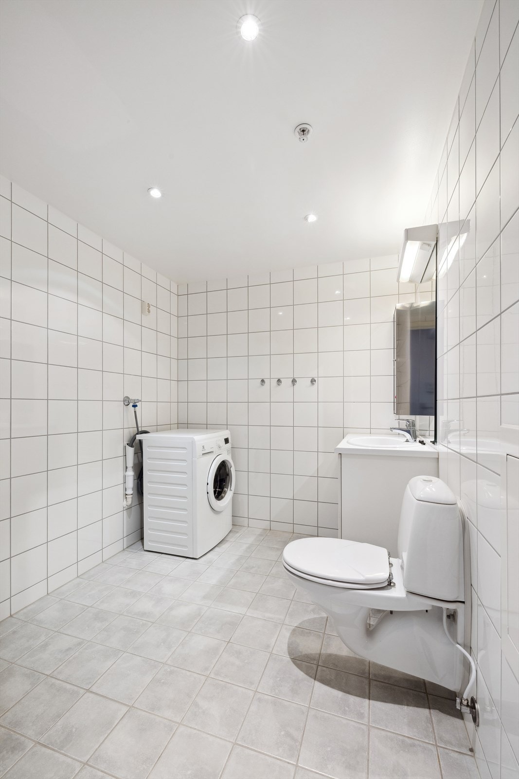 Flislagt bad med varmekabler i gulv og opplegg for vaskemaskin Galleribilde