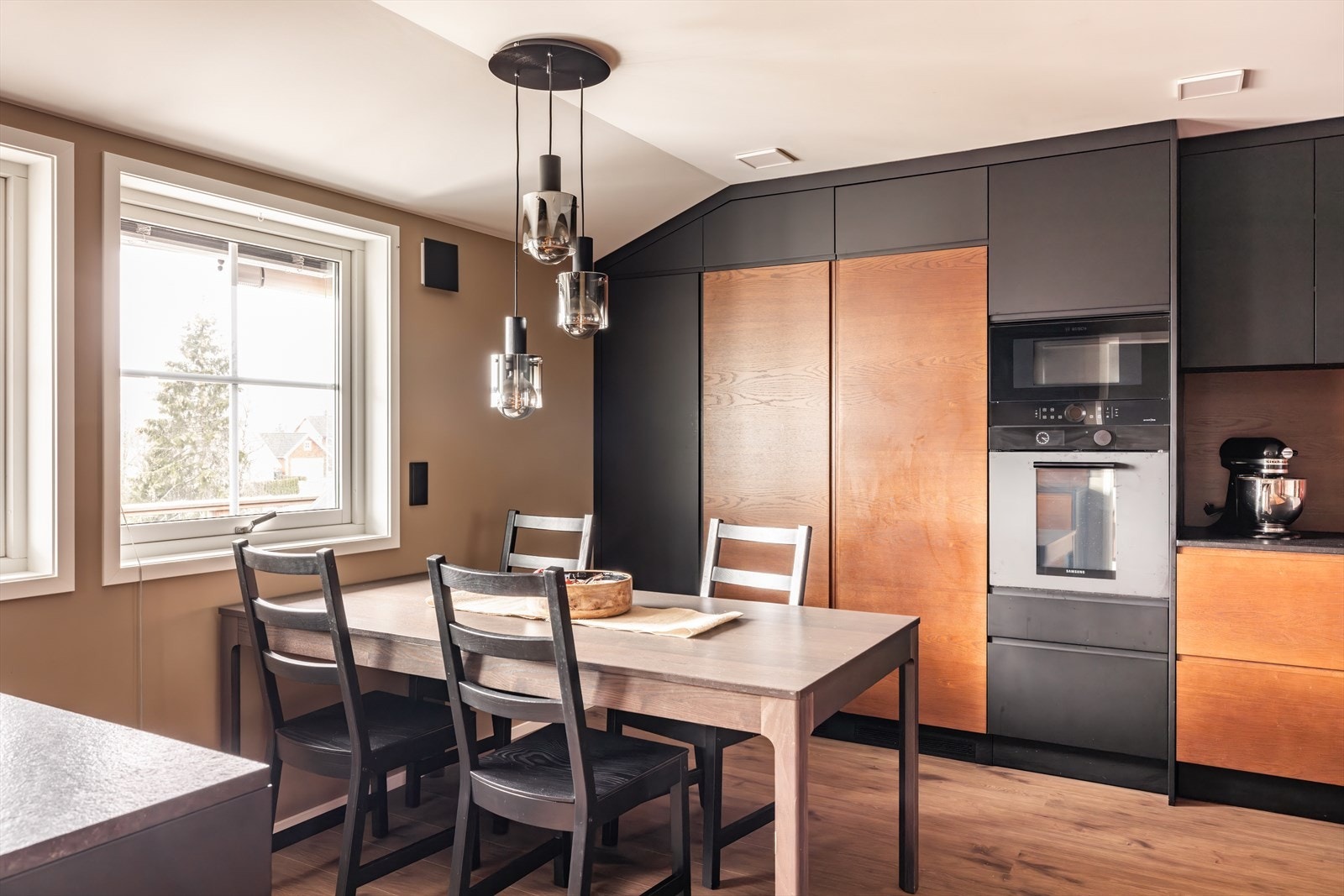 Kjøkkenet har en egen spiseplass med god plass til spisebord ved vinduet - et trivelig sted for både hverdagsmåltider og gjester. Galleribilde