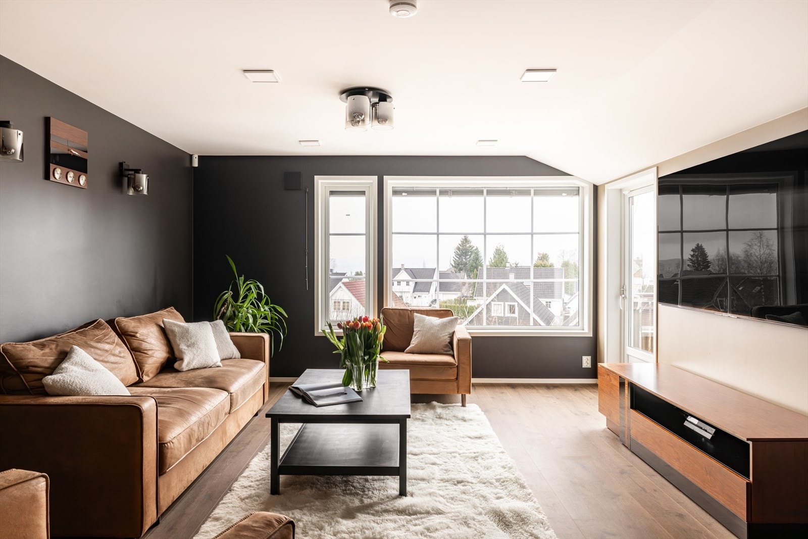 Stuen er innbydende og romslig, med store vindusflater som slipper inn rikelig med naturlig lys og gir fin utsikt mot nærområdet. Galleribilde