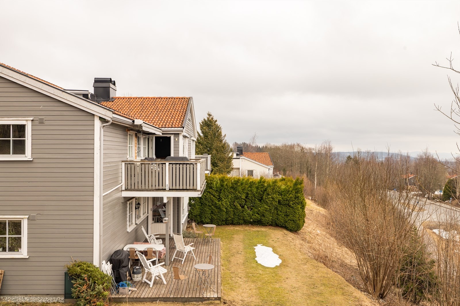 Eiendommen er beliggende i skrånende terreng med enkel adkomst til denne leiligheten fra oversiden av bygget med asfaltert dekke i gangvei fra garasje. Galleribilde