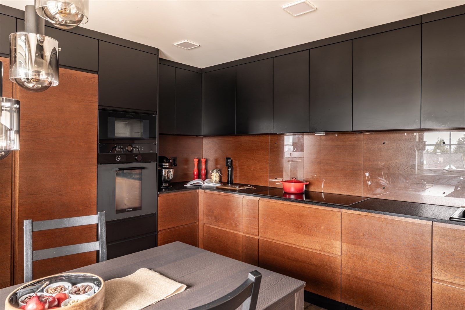 Innredningen er levert av Blum og består av både over- og underskap i en elegant kombinasjon av sorte, glatte fronter og varme trefinérflater. Galleribilde