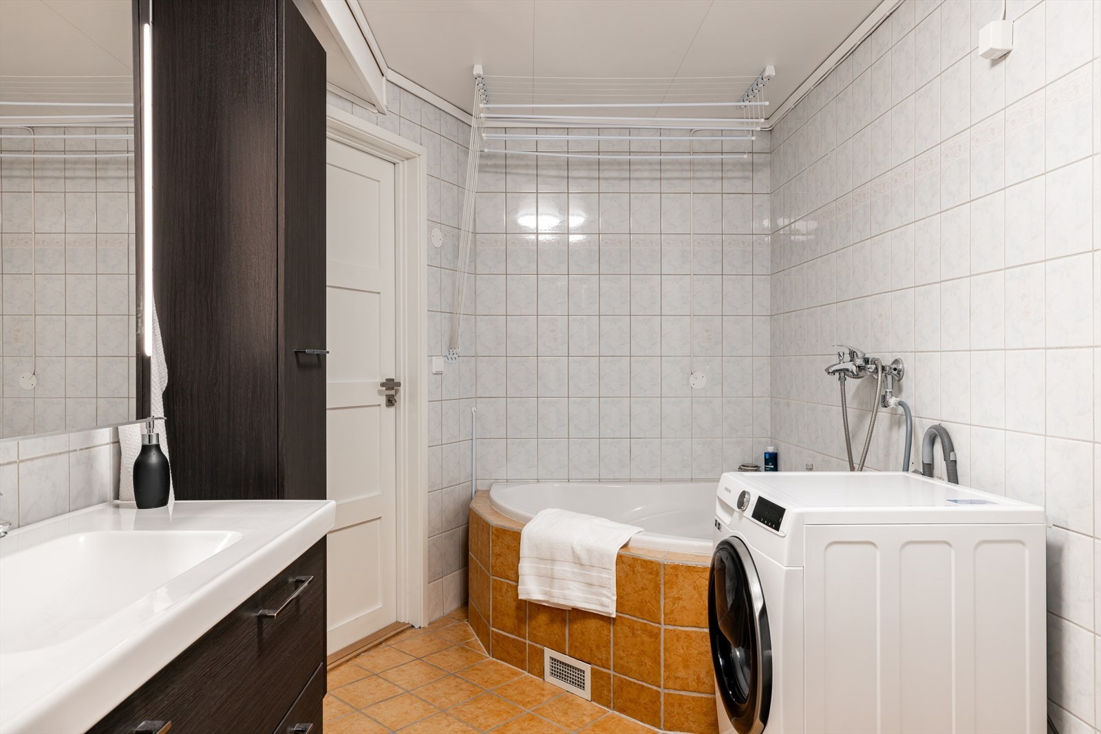 Rommet er utstyrt med innmurt hjørnebadekar, gulvmontert toalett, samt opplegg for vaskemaskin. Galleribilde