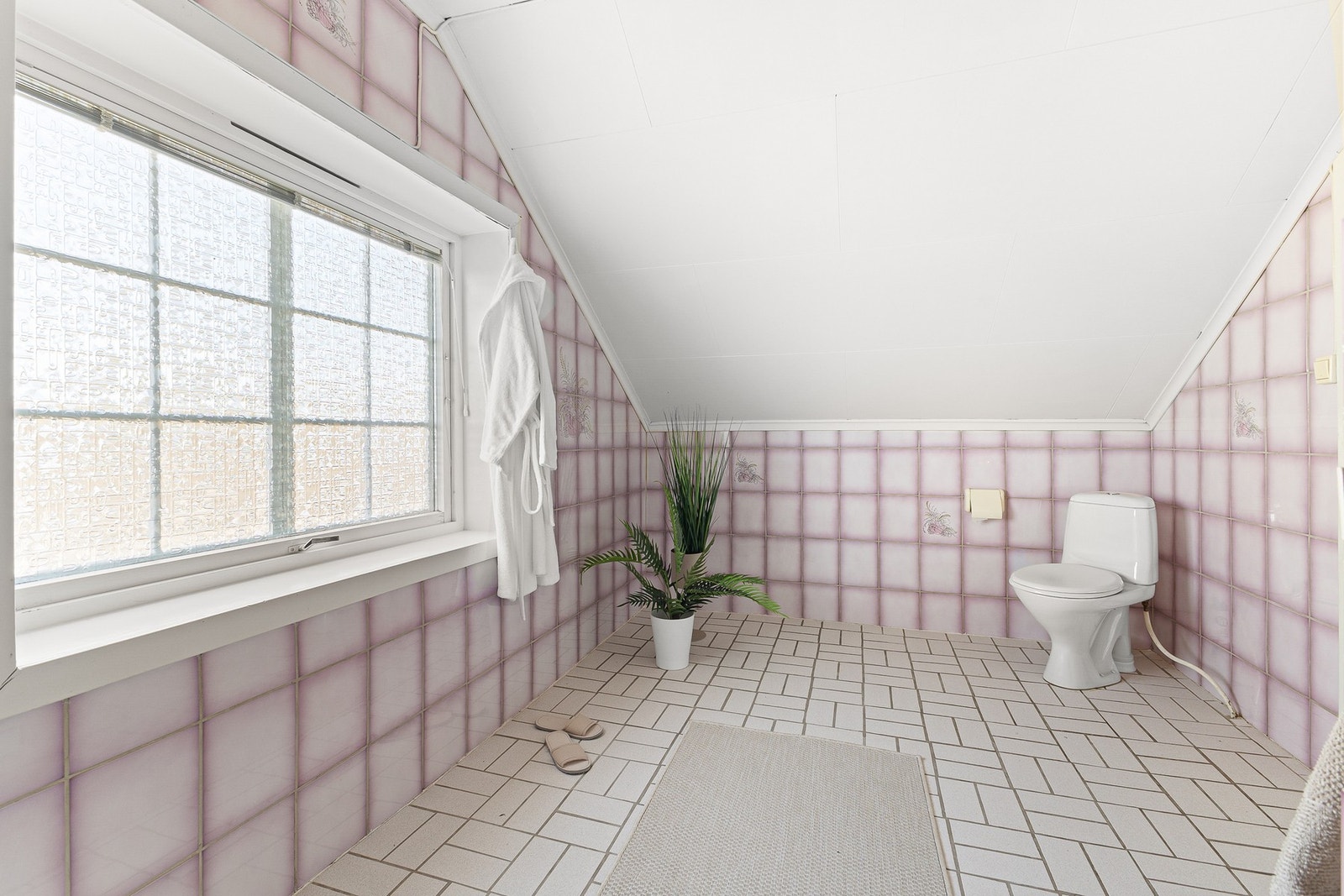 Badet i boligen har en funksjonell størrelse med fliser på både vegg- og gulvflater, noe som gir et helhetlig og lettstelt uttrykk. Galleribilde