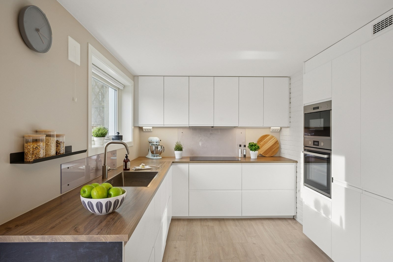 Kjøkkeninnredning med slette fronter og benkeplate i laminat. Kjøkkenet er praktisk utformet gode arbeidsflater. Galleribilde