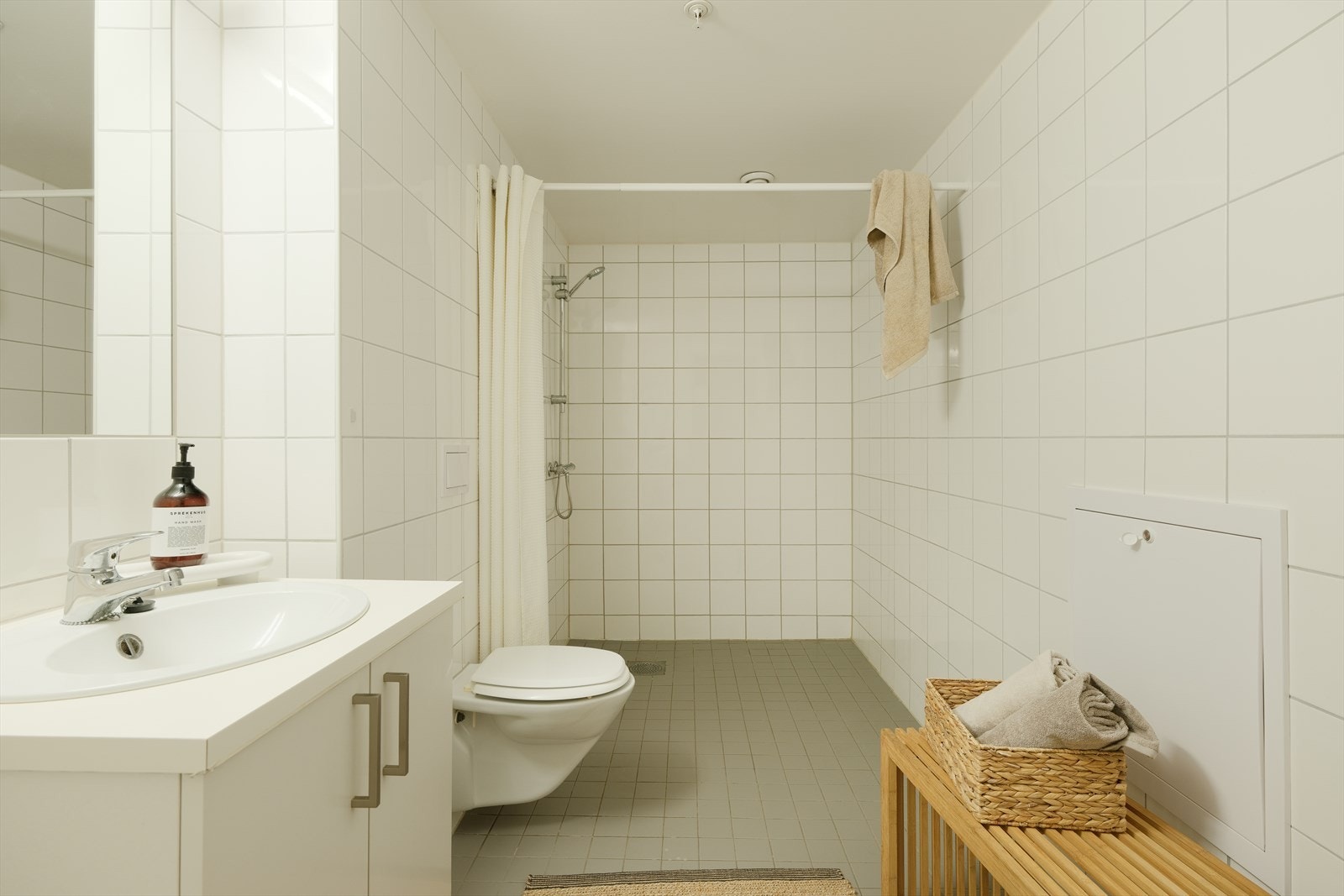 Svært romslig bad fra byggeår med dusj, toalett, servant og opplegg til vaskemaskin. Galleribilde