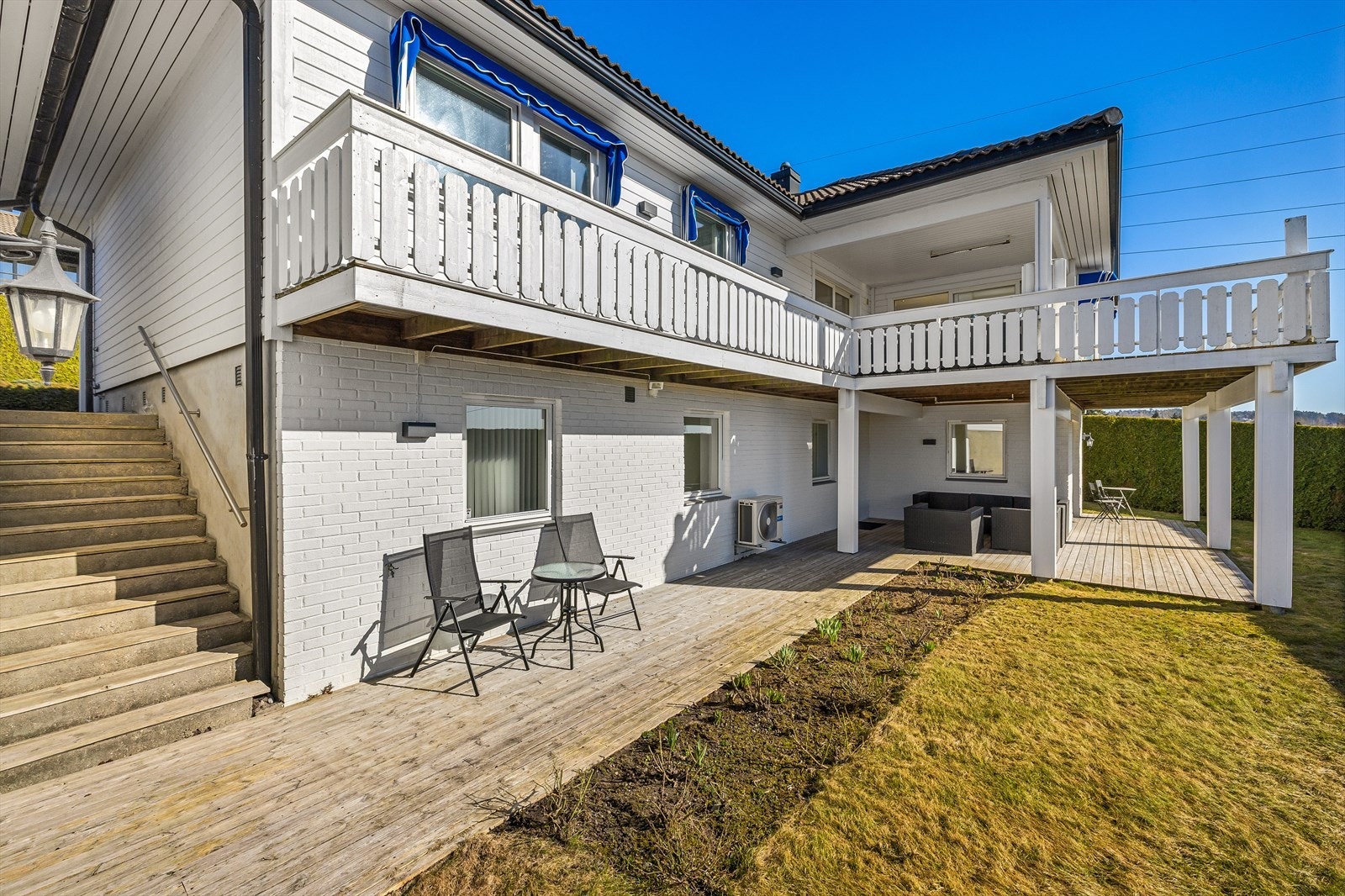 Tomten er opparbeidet over to nivåer, med platting og hageområdet på nedre del av tomten Galleribilde