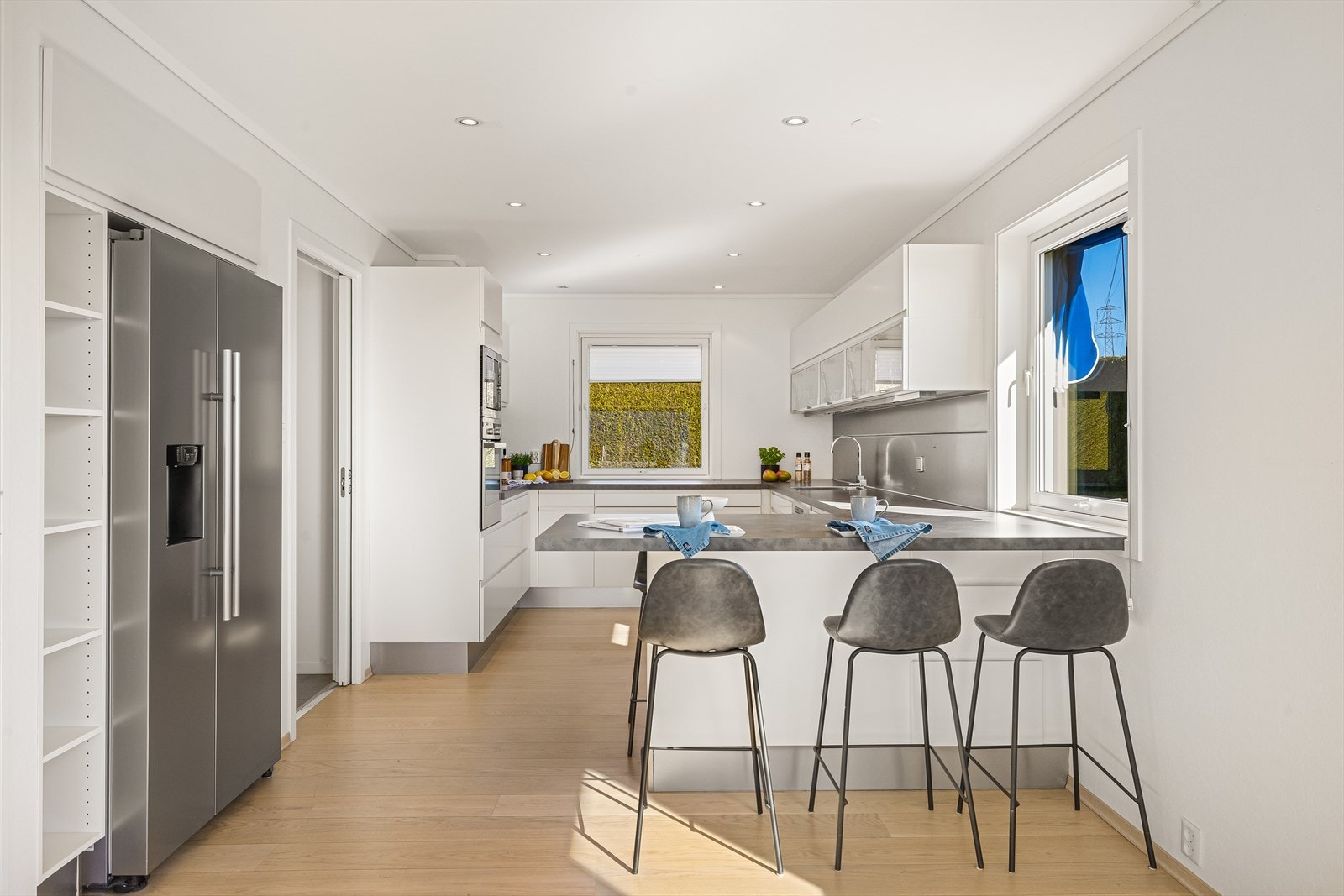 Kjøkkenet har stilren og moderne innredning, med sitteplass ved hyggelig barløsning mot stuen Galleribilde