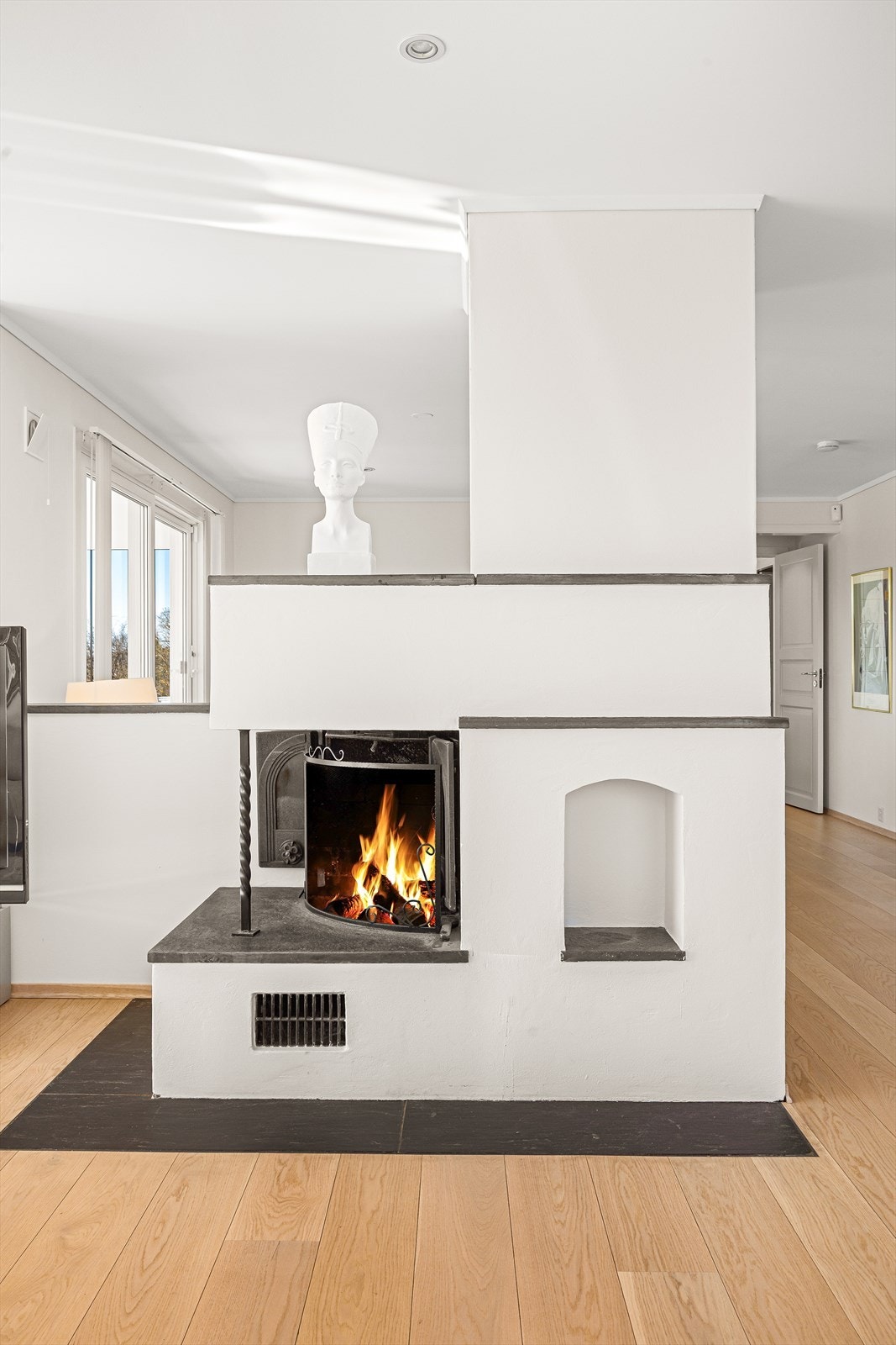 Stuen er innredet med åpen peisovn og varmepumpe som sørger for en hyggelig stemning og god oppvarming til boligens hovedetasje Galleribilde