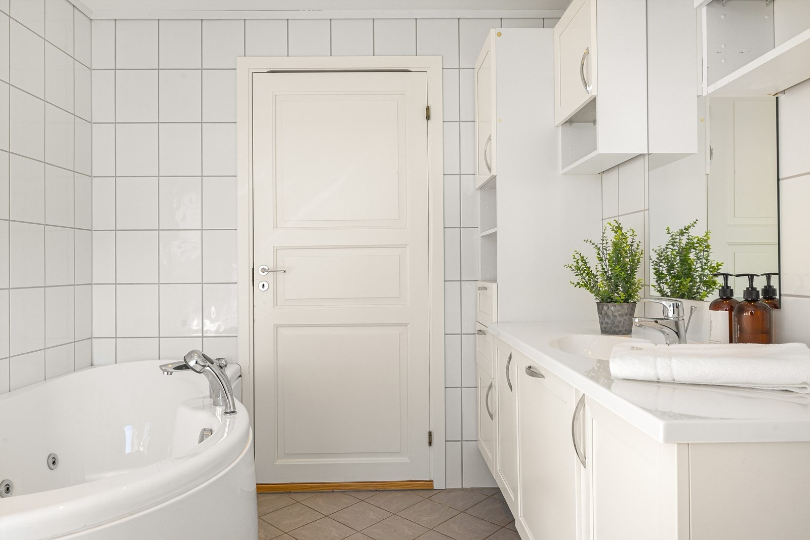 Baderomsinnredning med skuffer og overliggende servant, samt veggfestet høyskap med god oppbevaringsplass Galleribilde