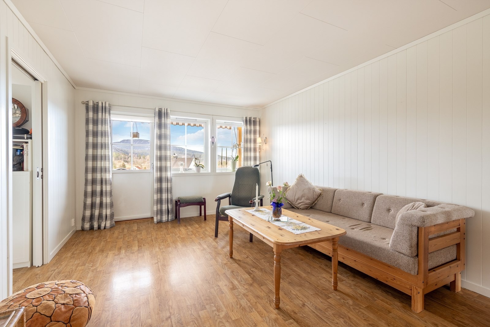 Stuen er pen og gjennomlys med plass til både sofagruppe og spisestuebord. Galleribilde