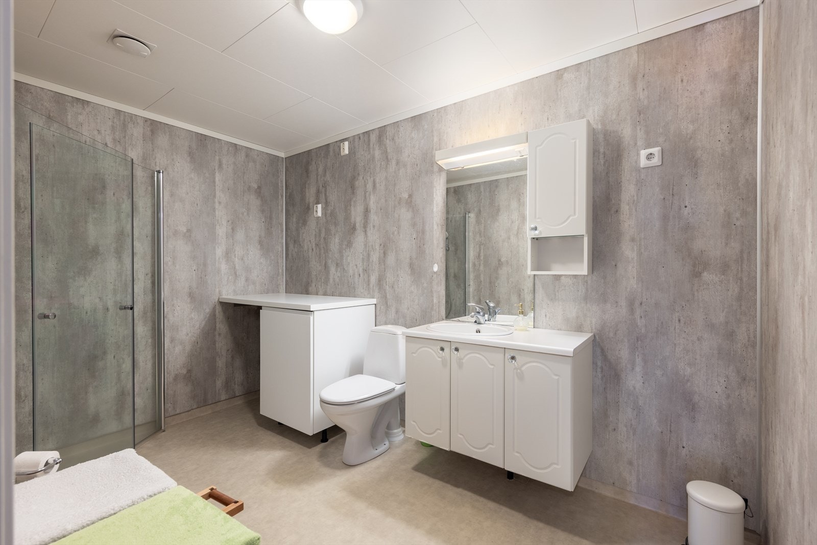 Romslig bad som ble oppgradert i 2020. Dusjhjørne, toalett og innredning med nedfelt vask og benkeplate, under- og overskap med profilerte fronter, speil og lys. Ekstra skap med benkeplate. Ventilasjon via luke i tak. Galleribilde