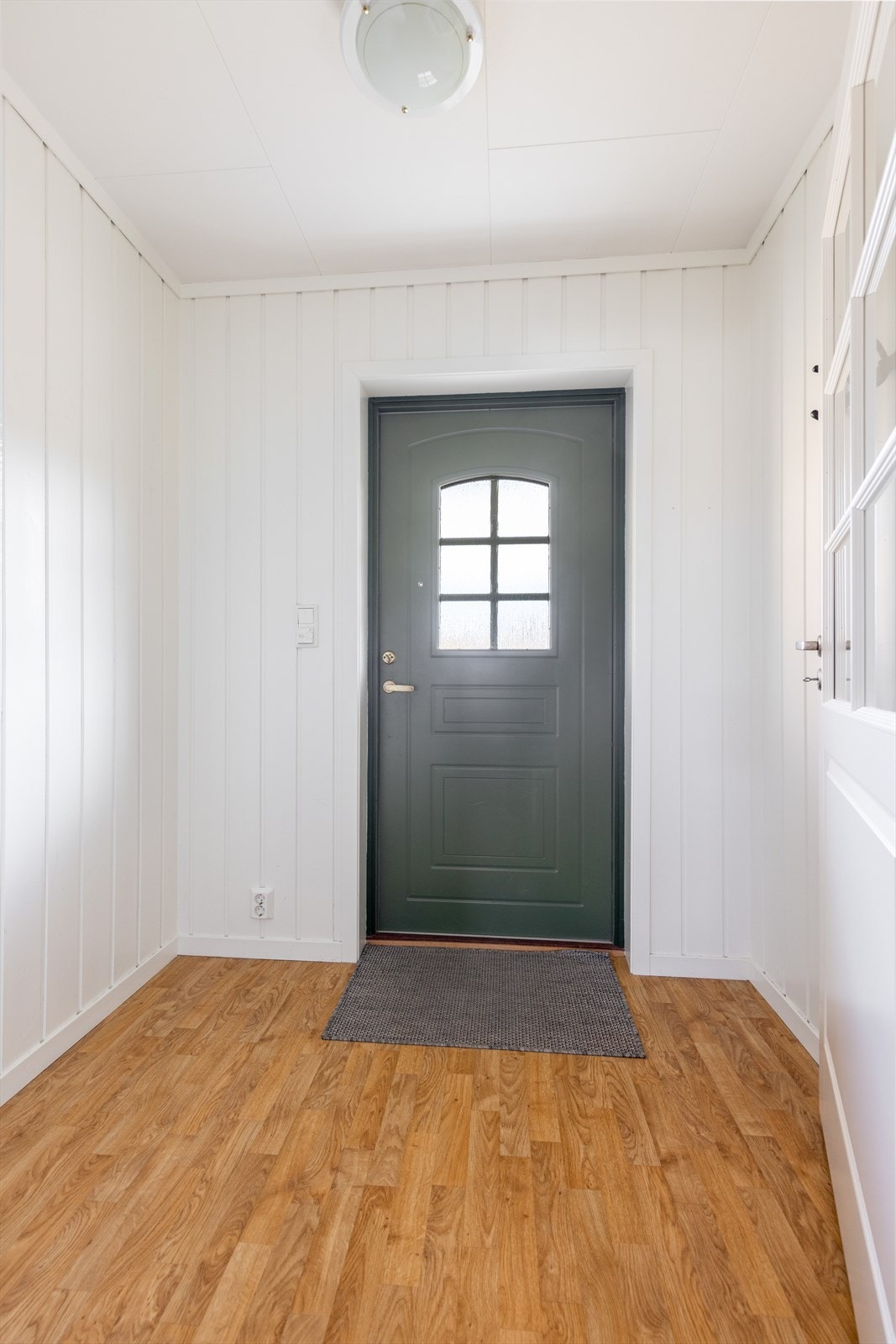 Mellom gangen og entreen er det en pen glassdør. Det er god plass til oppbevaring av sko og yttertøy. Galleribilde