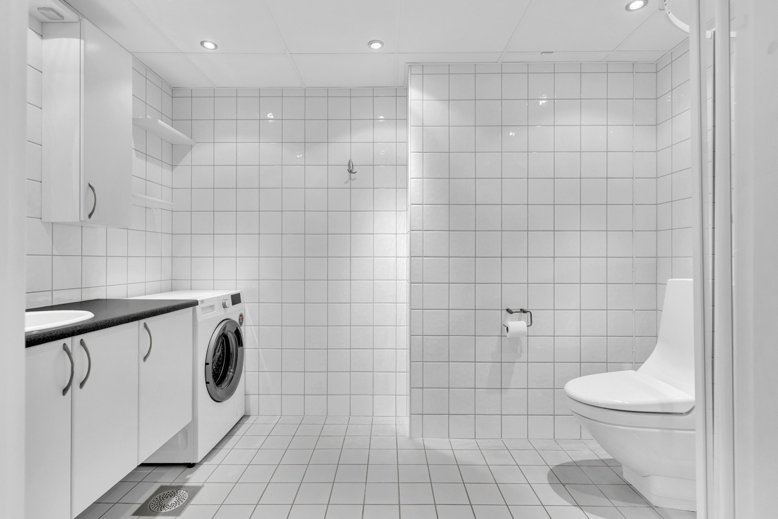 Helfliset baderom med varmekabler og systemhimling med downlightsbelysning. Galleribilde