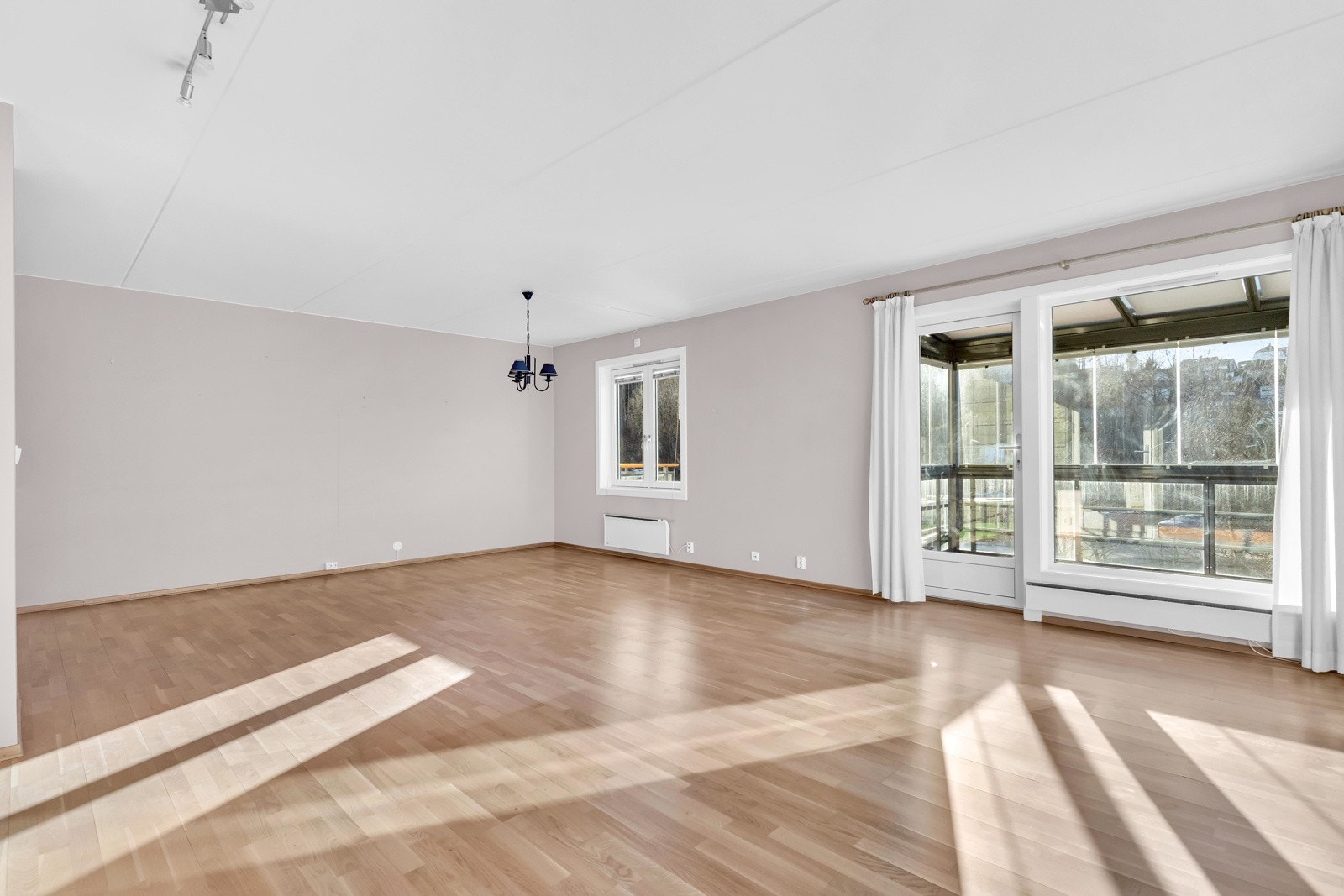 Rommet har en moderne fargepalett og parkett på gulvet. Galleribilde