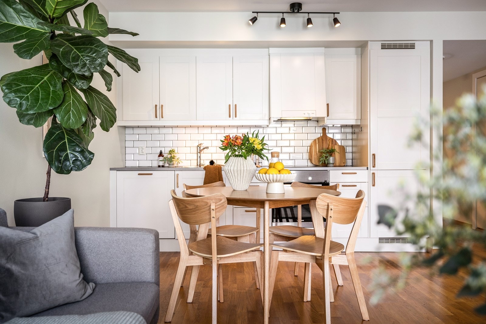 Kjøkkenet har hvite profilerte fronter, ny platetopp fra 2025 og fliser mellom kjøkkenbenk og overskap. Galleribilde