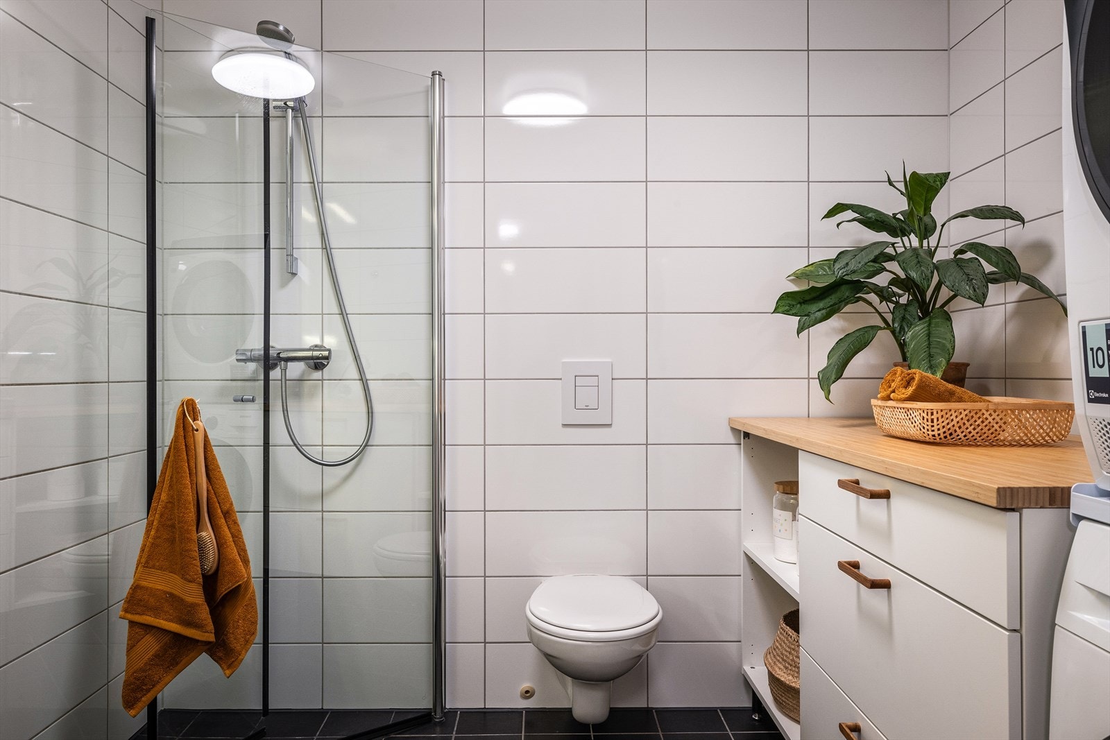 Badet er innredet med servantskap, vegghengt toalett, innfellbare dusjvegger og opplegg for vaskemaskin. Galleribilde