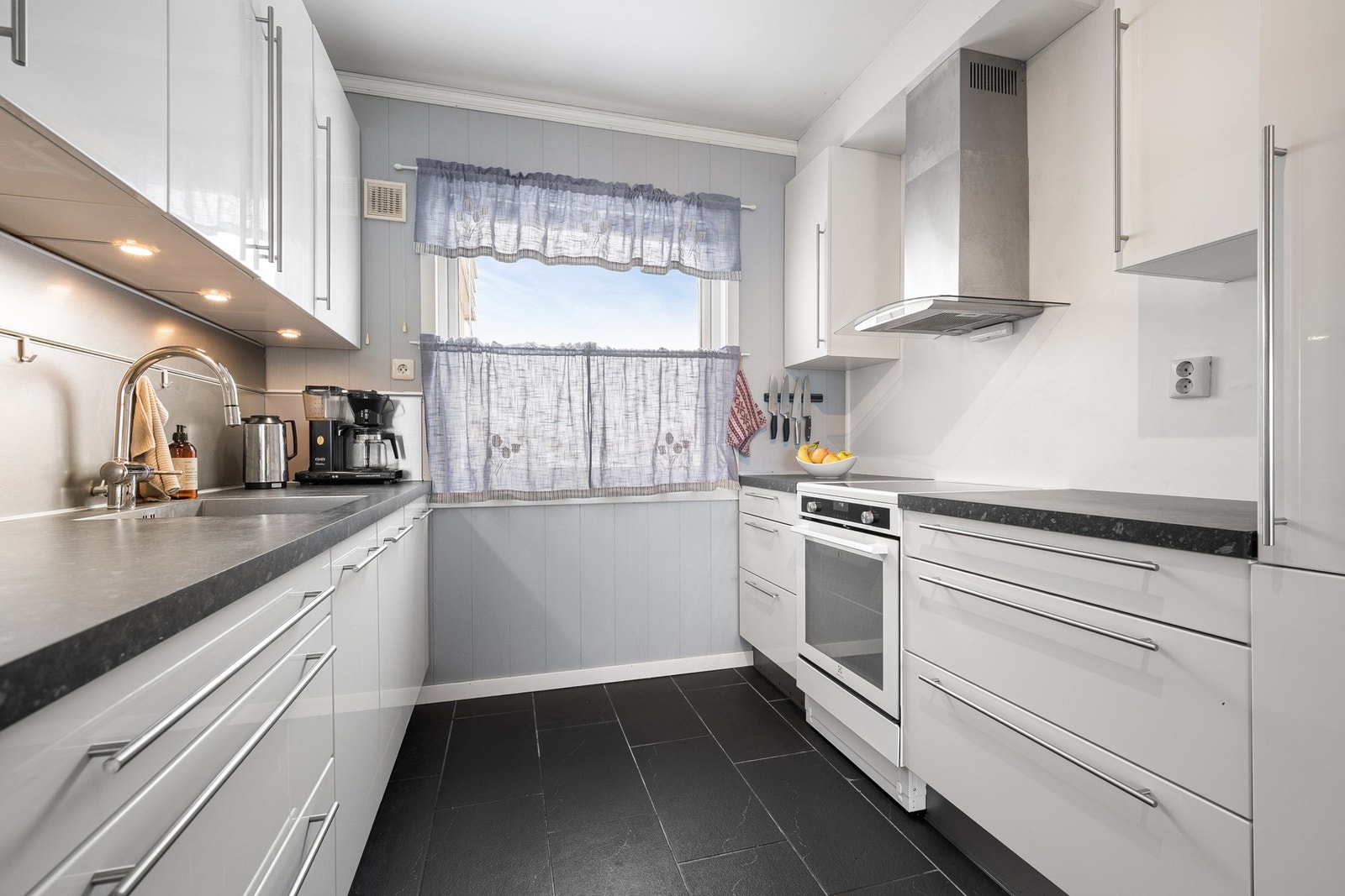 Kitchenboard mellom benkeplate og overskap ved vask Galleribilde