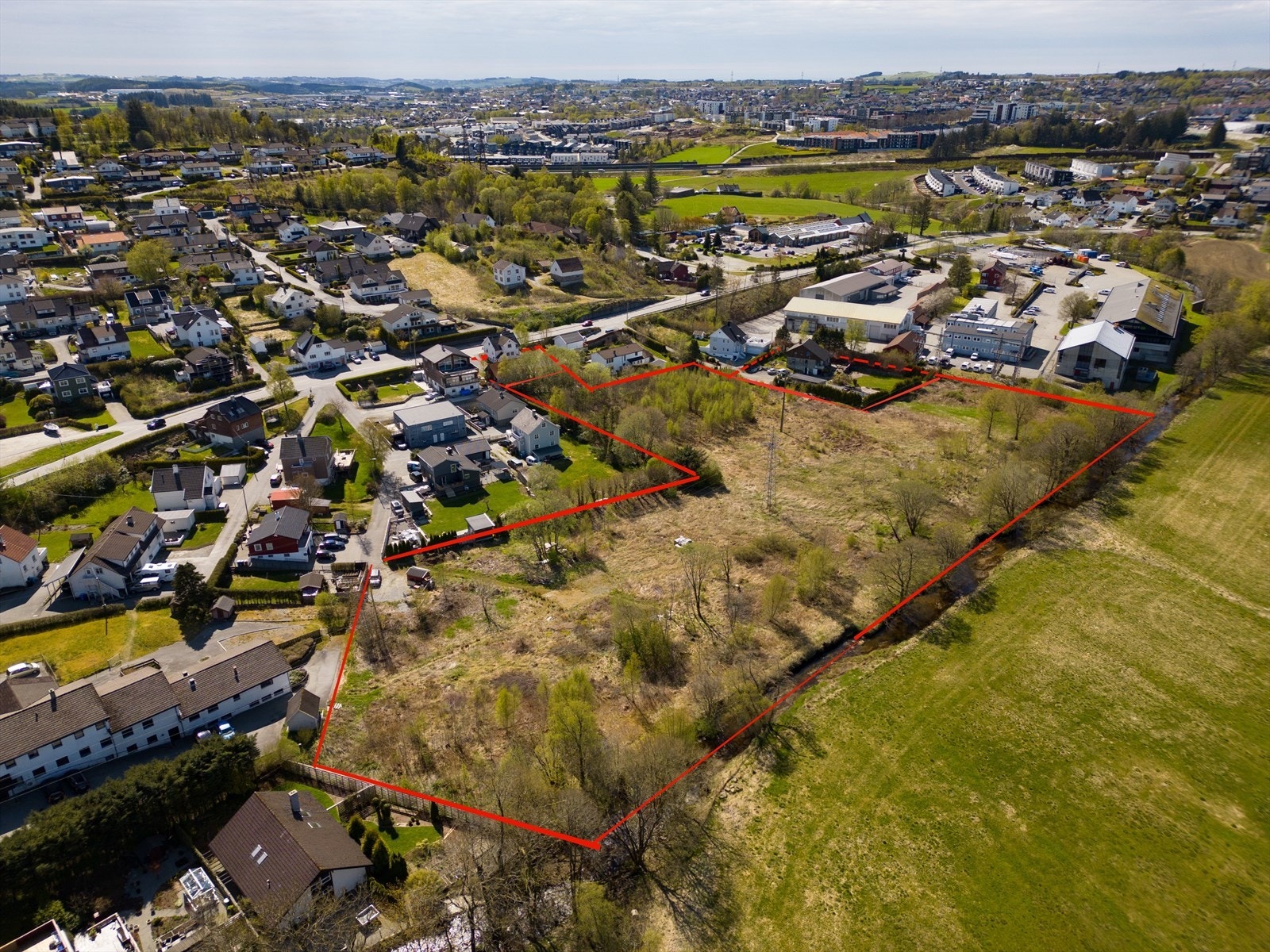 Tomtegrenser er tegnet inn for å gi en idé om tomtens utforming. De er ikke nøyaktige. Gamle Ålgårdsveien 120 som ligger helt inntil veien medfølger også. Boligeiendom innenfor stiplet linje til høyre i bildet selges separat. Galleribilde