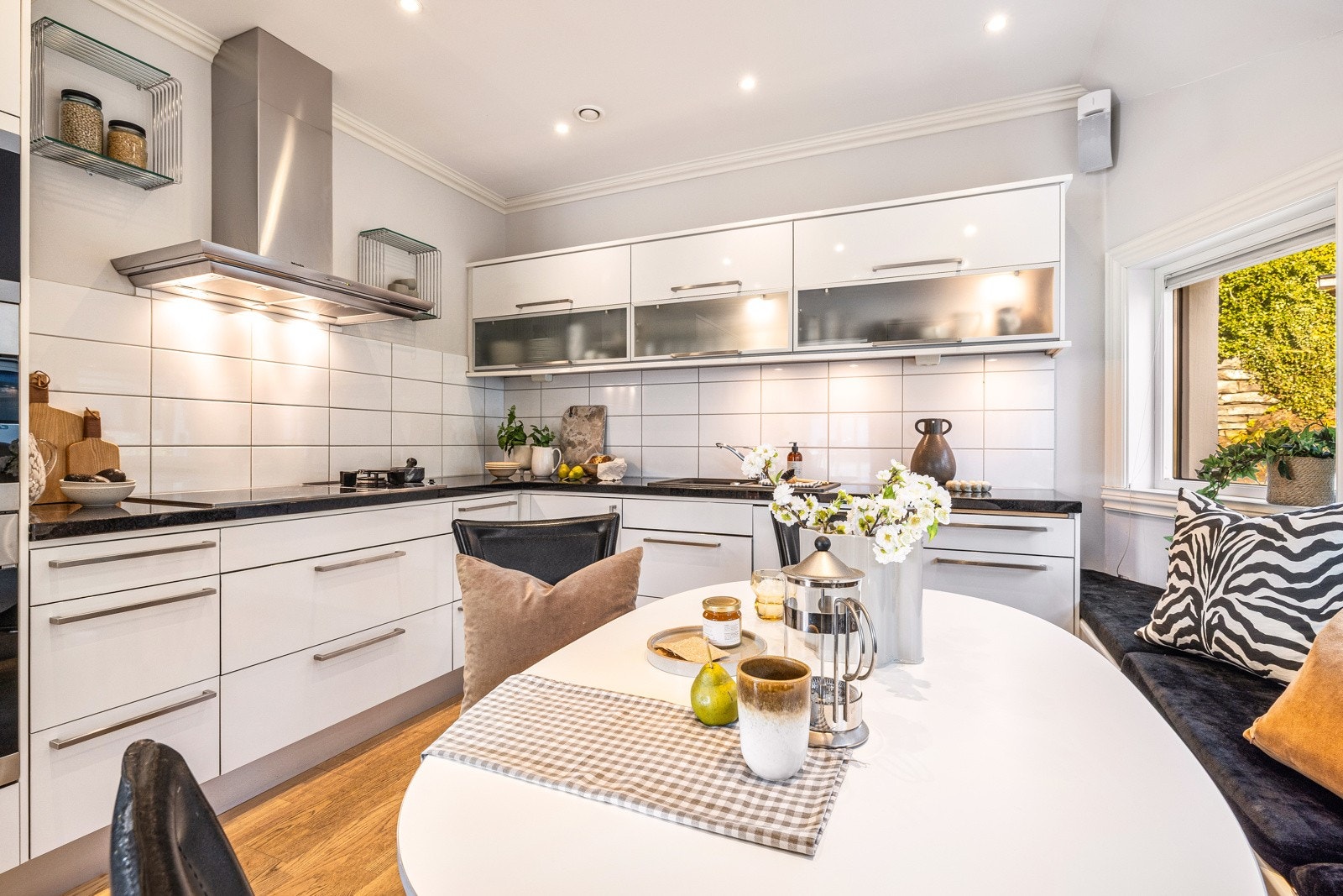 - Innredningen har slette hvite fronter og overskap med glassfelt, samt sort granitt benkeplate med fliser over - Galleribilde