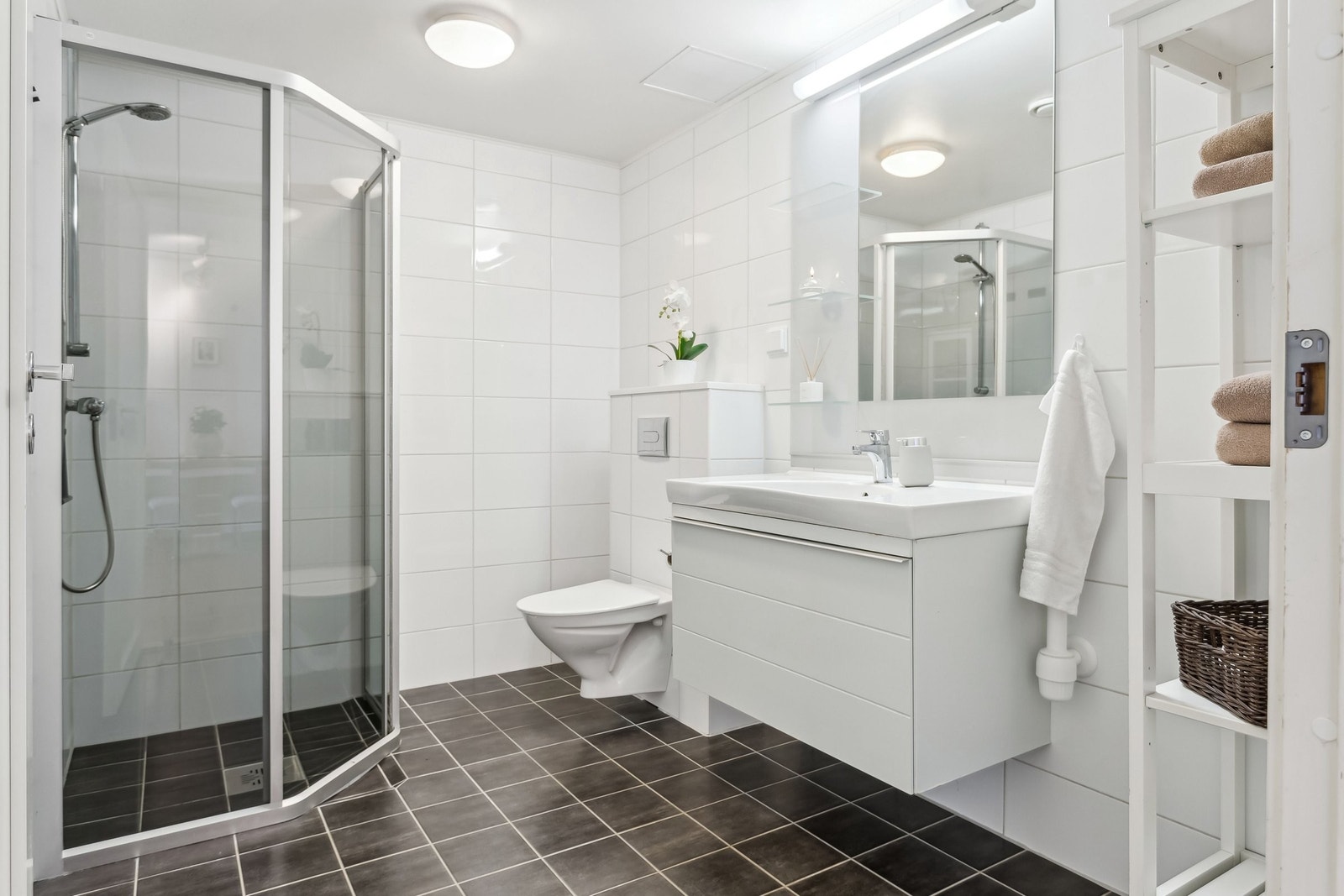 Badet er helfliset med varmekabler og dusj, vegghengt wc, servant og baderomsmøbler. Galleribilde