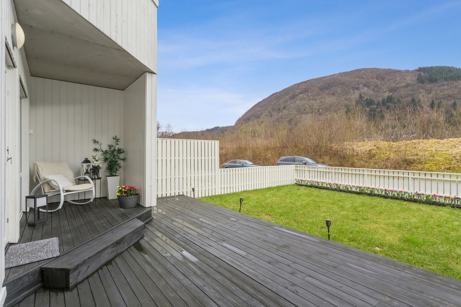 Inngjerdet hage med terrasse på ca 23 m2, og plen på ca 33 m2. Her er det morgen- og formiddagssol fra kl 07 på morgenen midtsommerstid. Galleribilde