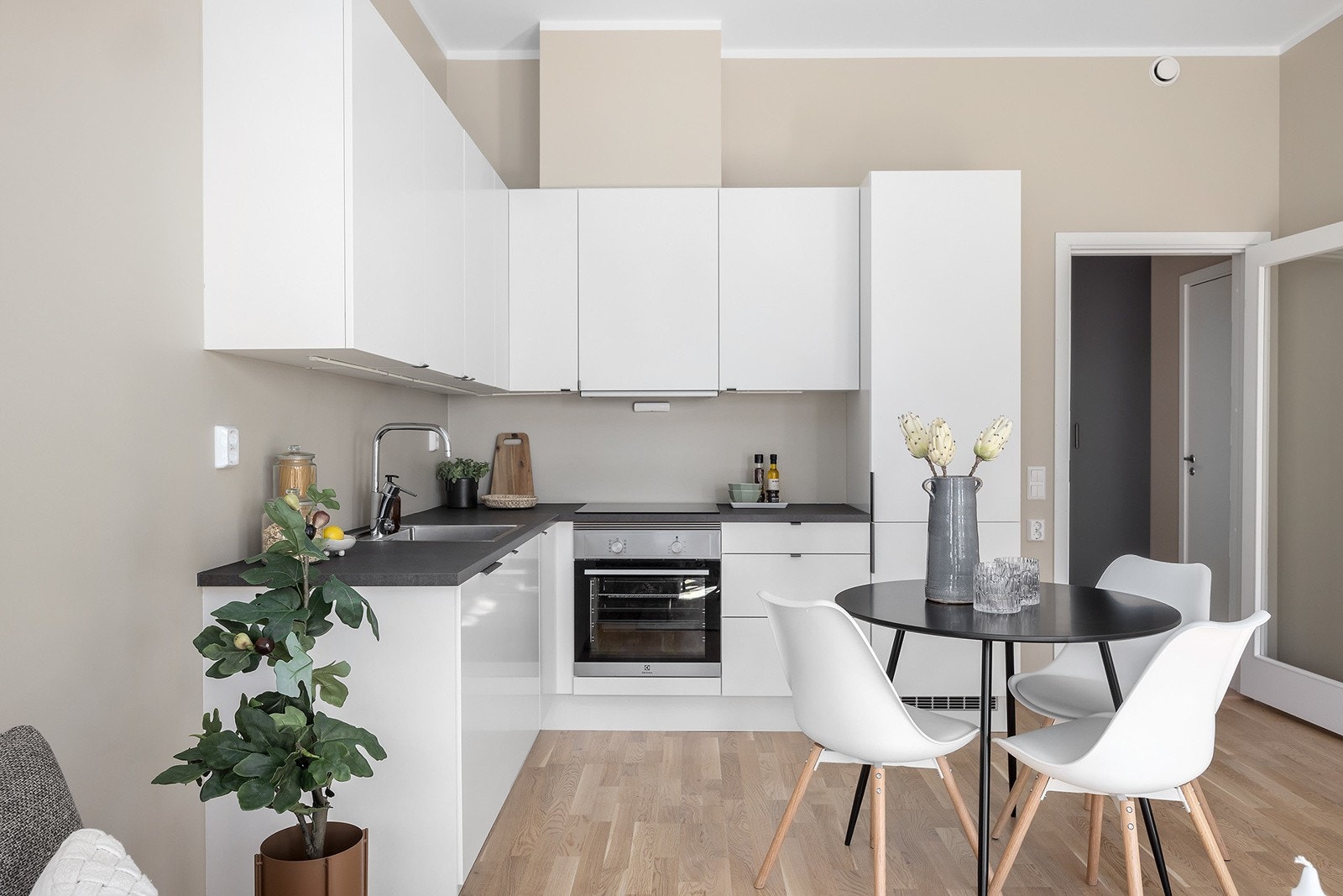 Kjøkkeninnredning består av glatte fronter og laminert benkeplate, nedfelt oppvaskkum, belysning mellom benkeplate og overskap, samt stikkontakter på vegg over benkeplate. Galleribilde