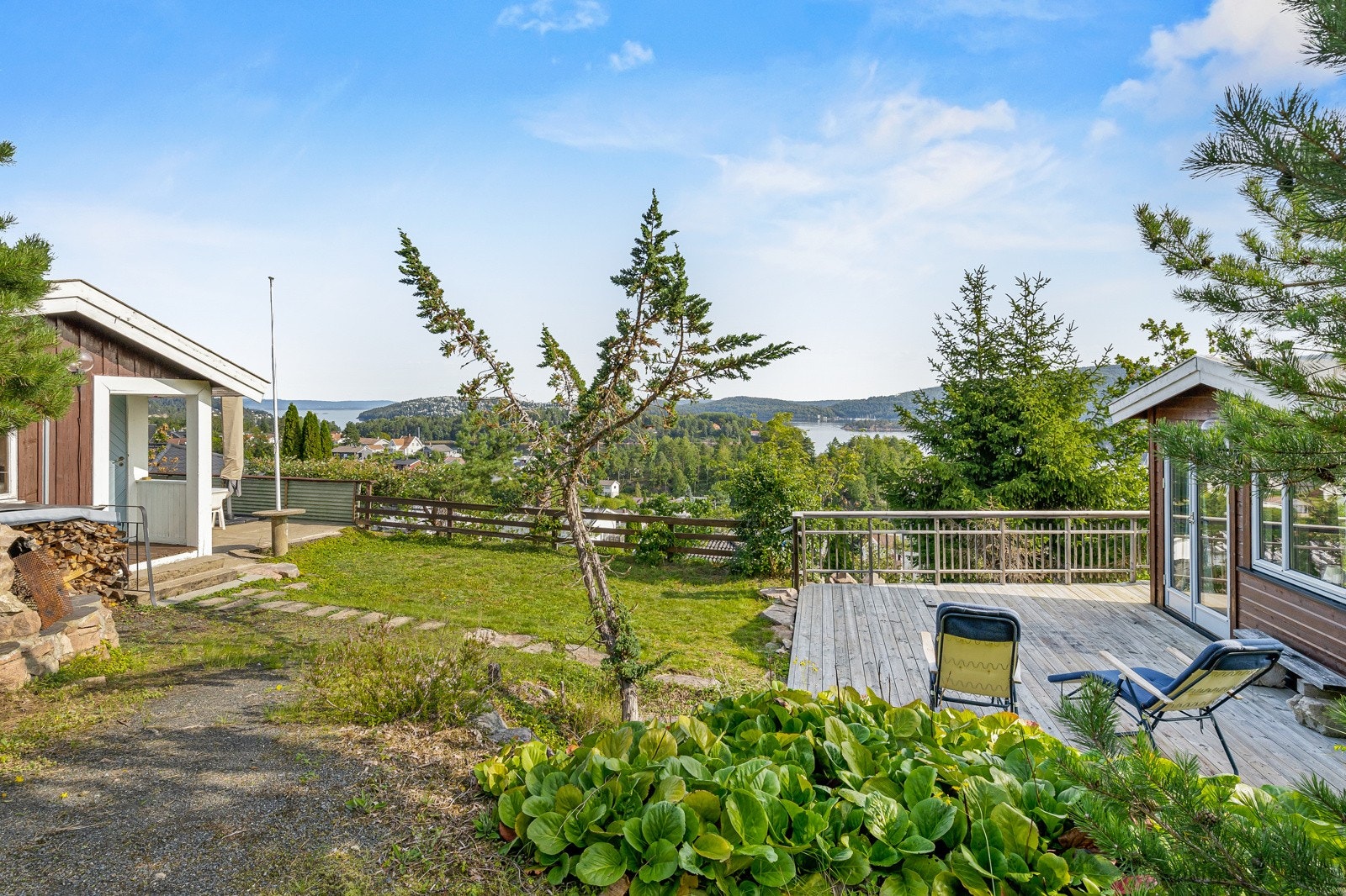Skrånende tomt opparbeidet med singlet/naturlig oppkjørsel, naturtomt, utepeis og diverse beplantning. Galleribilde