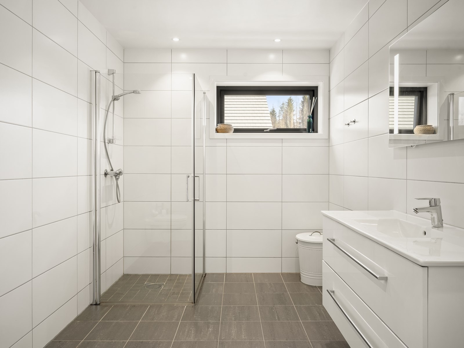 De to badene i boligen har gjennomgående stil med tidløse fargevalg på fliser og innredning. Galleribilde