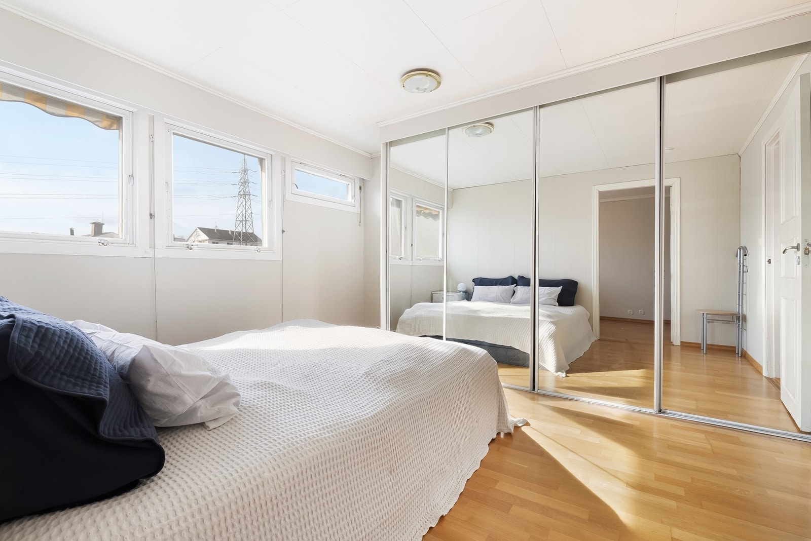 Langs den ene veggen er det skyvedørsgarderobe med speilfronter. Galleribilde