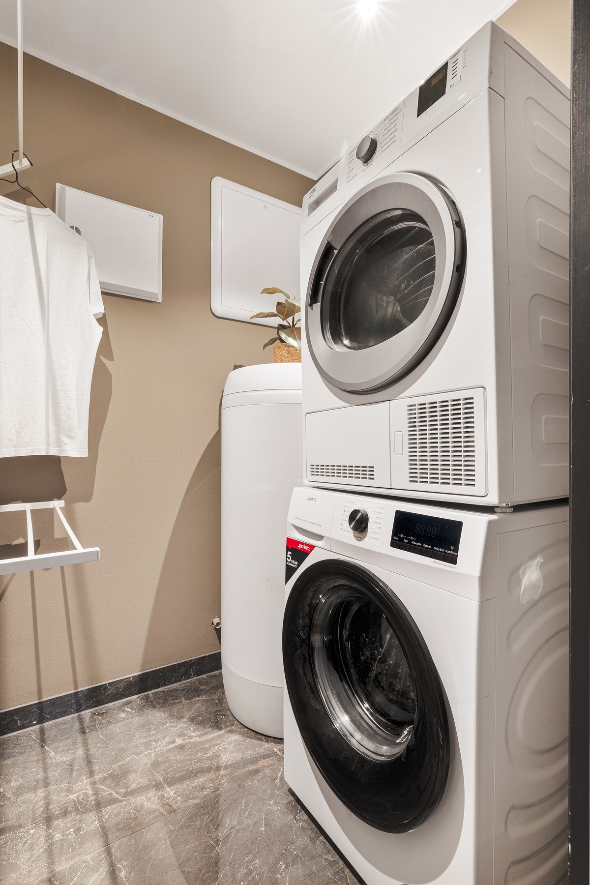 Vaskerom med varmtvannstank og opplegg for vaskemaskin. Også her er det varmekabler i gulvet Galleribilde